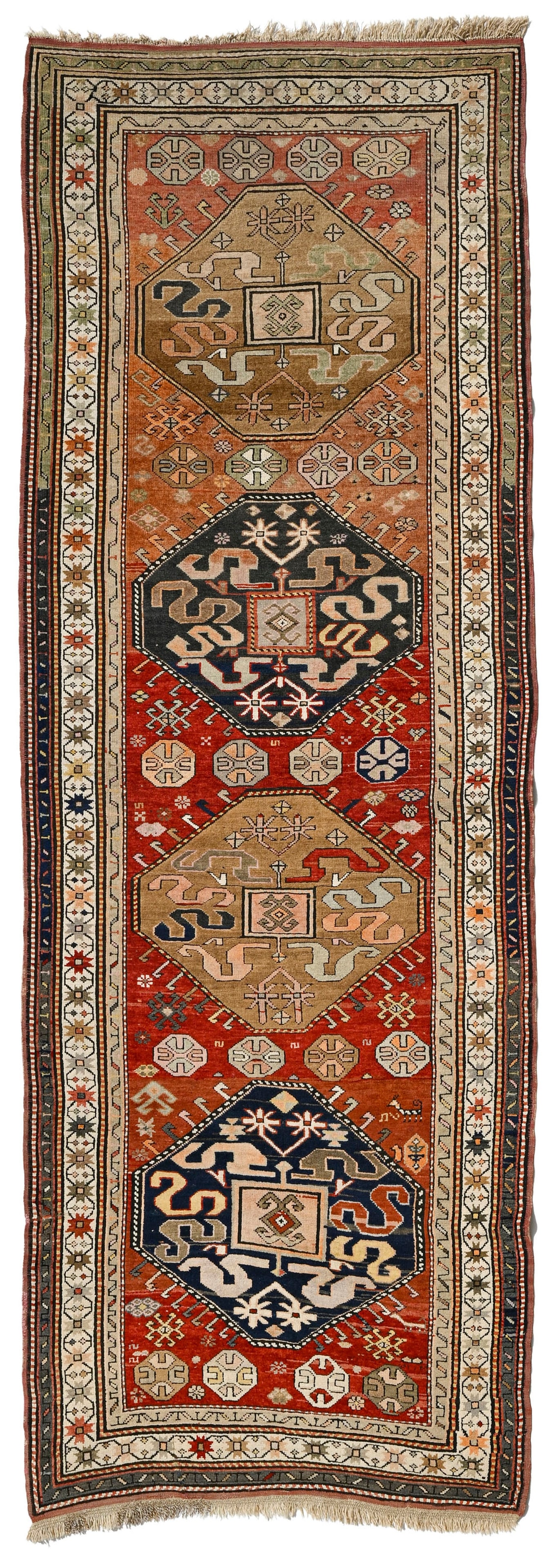 Tapis Kazakh, Caucase, 2ème tiers du XXe s., à décor de bandes de nuages inscrits dan: Tapis Kazakh, Caucase, 2ème tiers du XXe s., à décor de bandes de nuages inscrits dans quatre octogones beiges et bleus sur fond rouge parsemé de motifs géométriques,