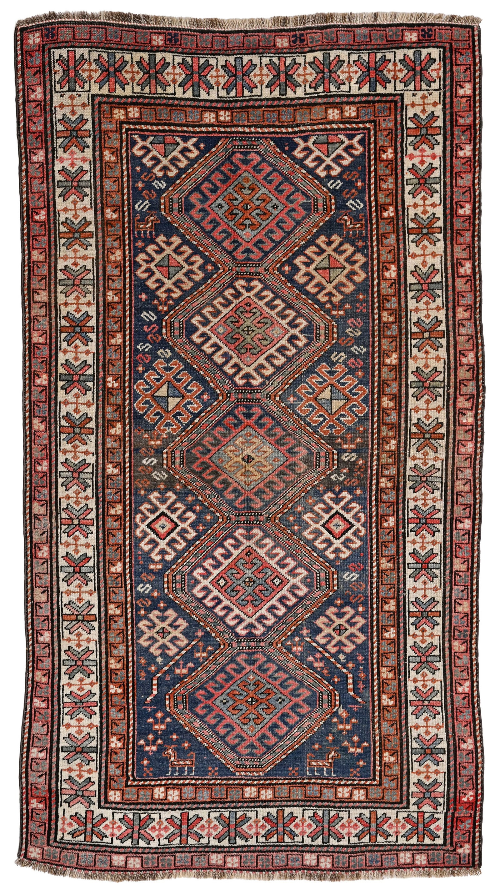 Tapis Kazakh, Caucase, milieu du XXe s., à semis de médaillons à crochets sur fond bl: Tapis Kazakh, Caucase, milieu du XXe s., à semis de médaillons à crochets sur fond bleu parsemé de fleurs et d'animaux stylisés, bordure beige étoilée, 112x204 cm