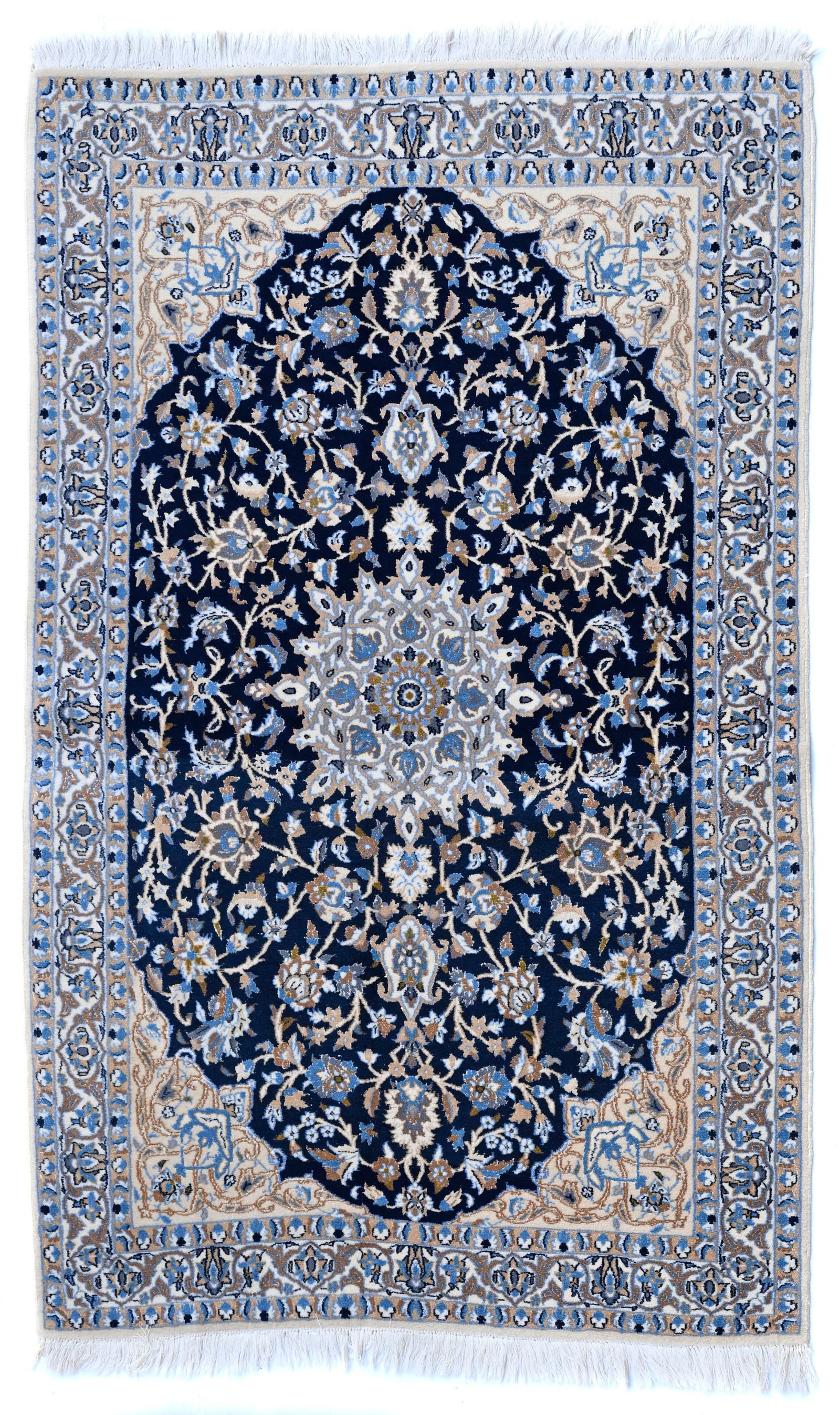 Tapis à dessin Naïn en laine avec soie, Inde, 2ème moitié du XXe s., à m: Tapis à dessin Naïn en laine avec soie, Inde, 2ème moitié du XXe s., à médaillon central beige sur fond bleu marine orné de rinceaux fleuris, bordure beige à