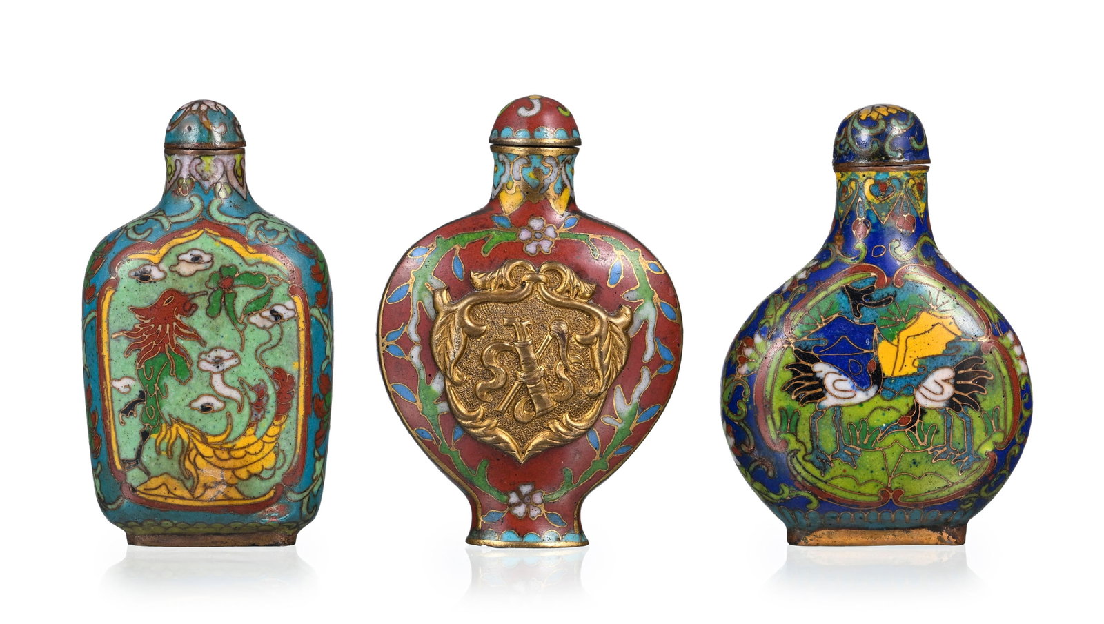 Ensemble de 3 flacons à priser en émaux cloisonnés, Chine, XXe s.: 1 orné de gru: Ensemble de 3 flacons à priser en émaux cloisonnés, Chine, XXe s.: 1 orné de grues dans des cartouches sur fond de fleurs, 1 décoré de phœnix et dragon dans des cart