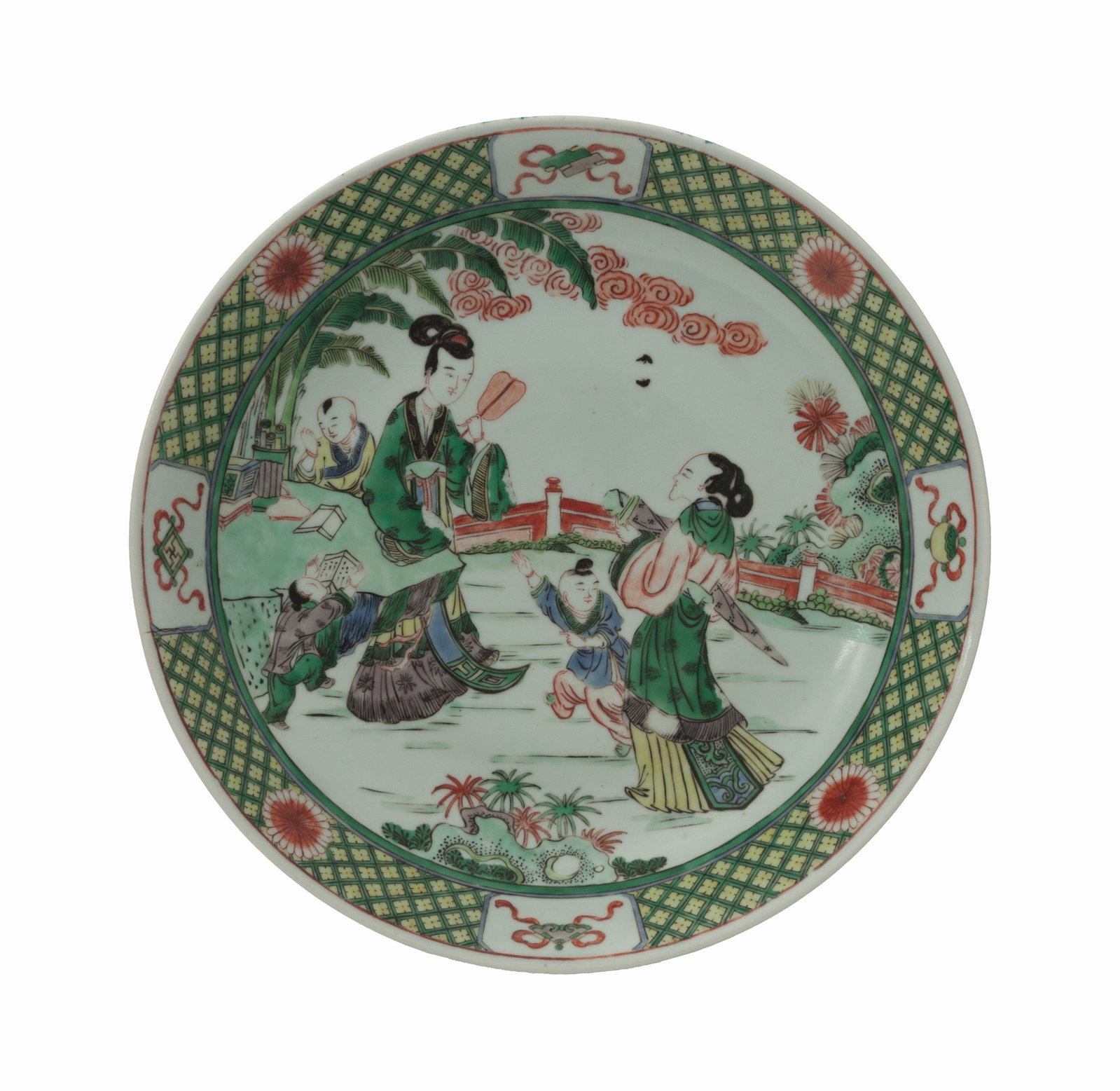 Grand plat creux en porcelaine famille verte, Chine, XIX-XXe s., décor de femmes et enfants dan: Grand plat creux en porcelaine famille verte, Chine, XIX-XXe s., décor de femmes et enfants dans un jardin, marli décoré d'emblèmes précieux, fleurs et motifs