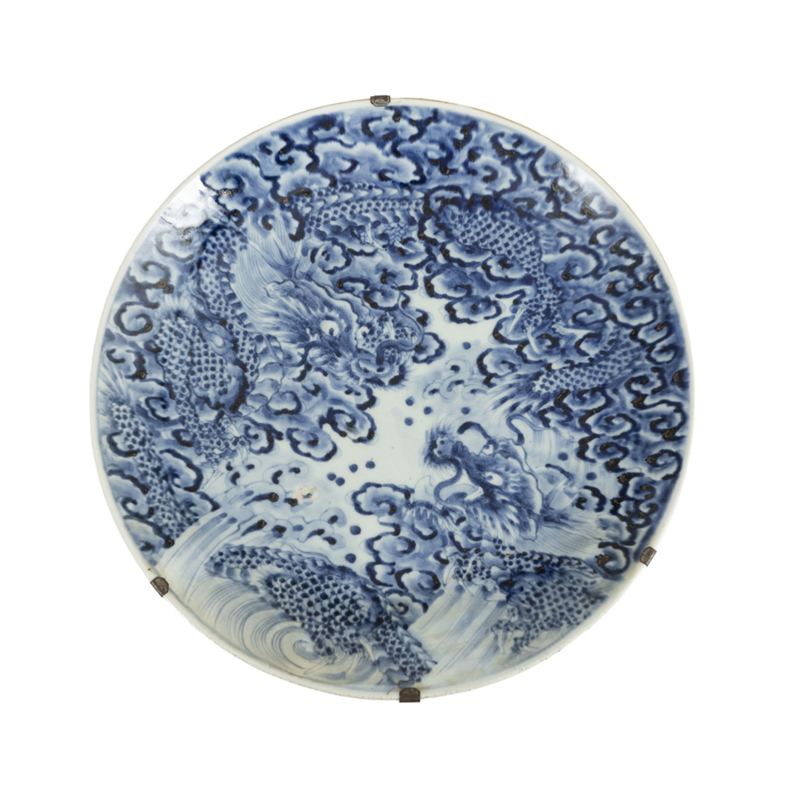 Plat en porcelaine, Japon, époque Meiji, décor en bleu de dragons parmi flots et nuée: Plat en porcelaine, Japon, époque Meiji, décor en bleu de dragons parmi flots et nuées, diam. 40 cm A blue and white porcelain charger, Japan, Meiji period, 40 cm diameter Condition