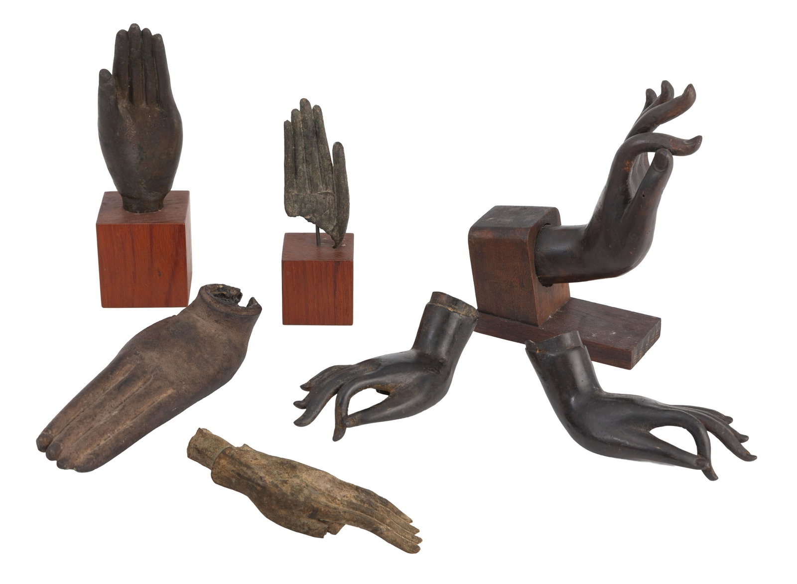 Ensemble de 7 mains en bronze, Thaïlande, XVIII-XXe s.: dont 3 sur socle en bois et 4 sans socl: Ensemble de 7 mains en bronze, Thaïlande, XVIII-XXe s.: dont 3 sur socle en bois et 4 sans socle, 3 adoptant l'abhaya mudra, 3 la vitarka mudra et 1 la pallava mudra, tailles diverses. On joint