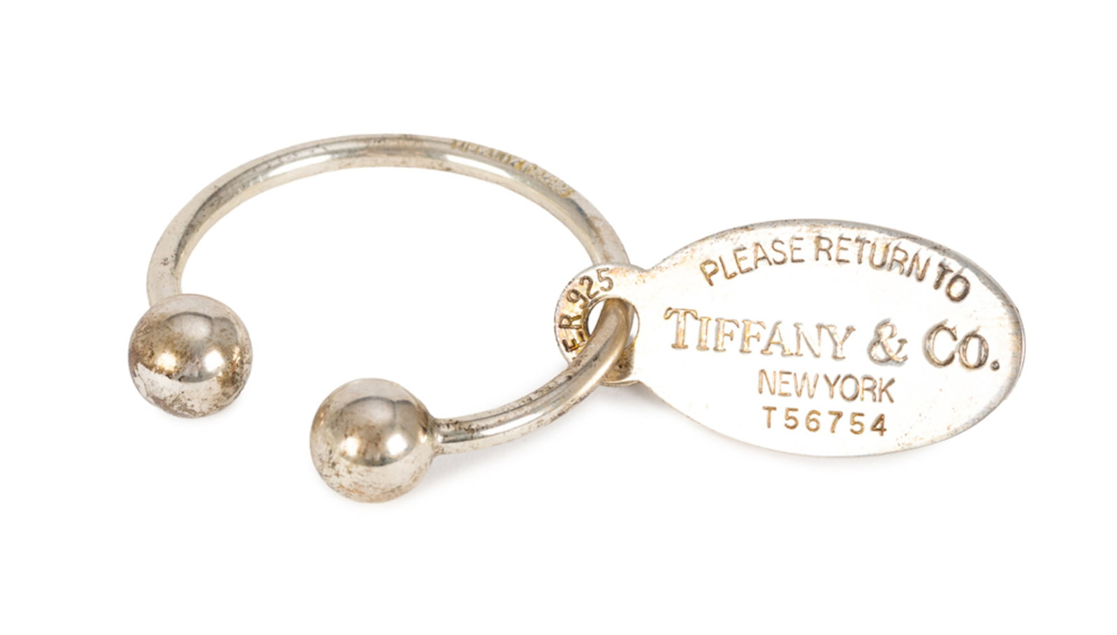 Tiffany & Co, porte clef ovale en argent 'Return to Tiffany' tag, housse, boîte: Tiffany & Co, porte clef ovale en argent 'Return to Tiffany' tag, housse, boîte Condition dates ciselées au verso: 7.VI.73 7.VI.98