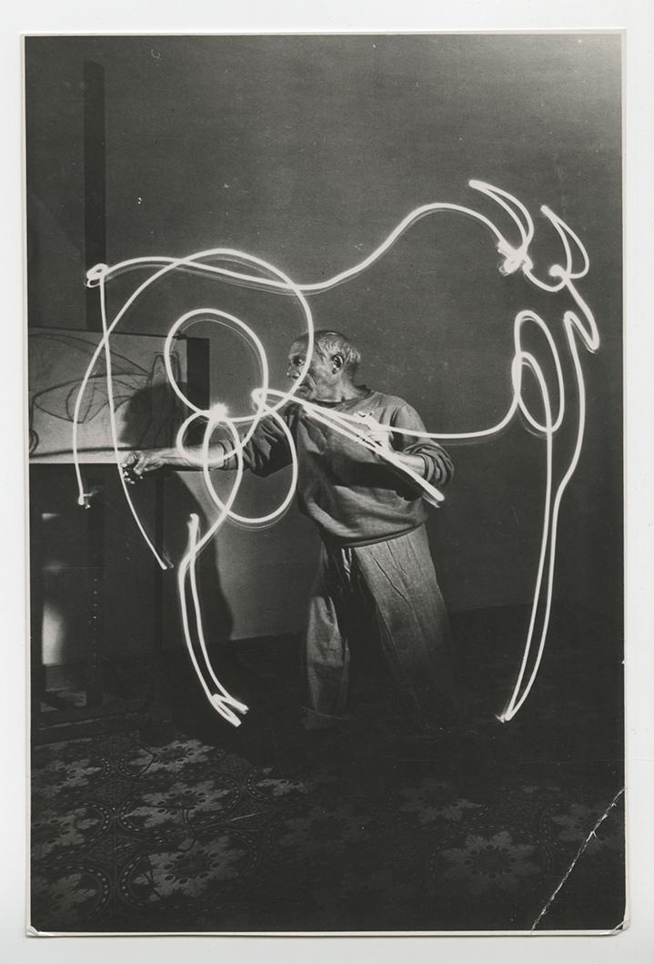 Gjon Mili, Picasso Light Drawing, c. 1940s: Gjon Mili, Picasso making a light drawing of a bull, c. 1940s. gelatin silver print, 6 1/2 x 4 1/4 inches. Condition is good, crease bottom right corner Artist portrait, Flash photography, long exposu