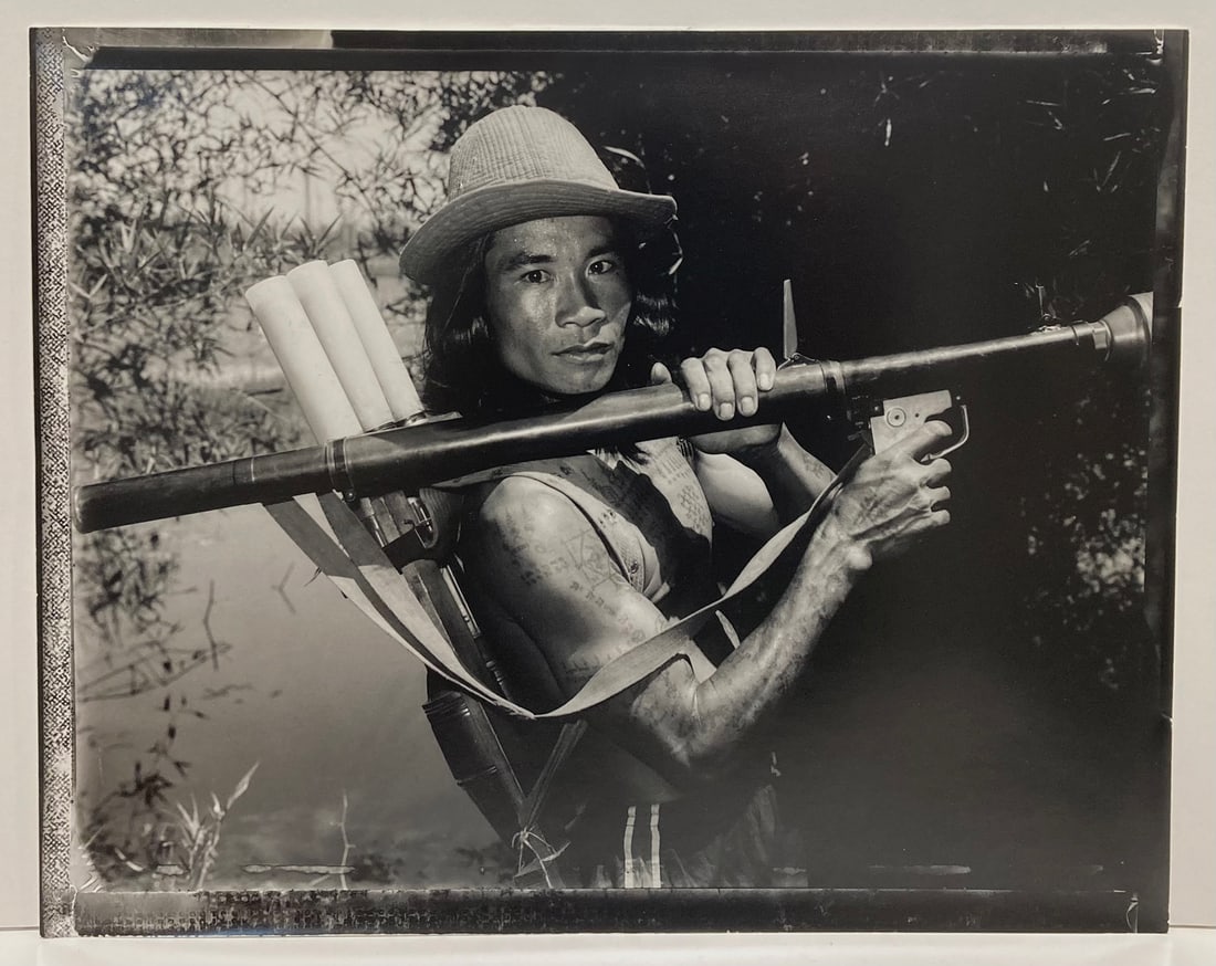 Bill Burke, KPNLF Fighter, 1984: Bill Burke, KPNLF Fighter with RPG, Lake Ampil, 1984. gelatin silver print from a Polaroidnegative, 16 x 20 inches. Signed, titled, and dated on the print verso. Condition is excellent, less to minor