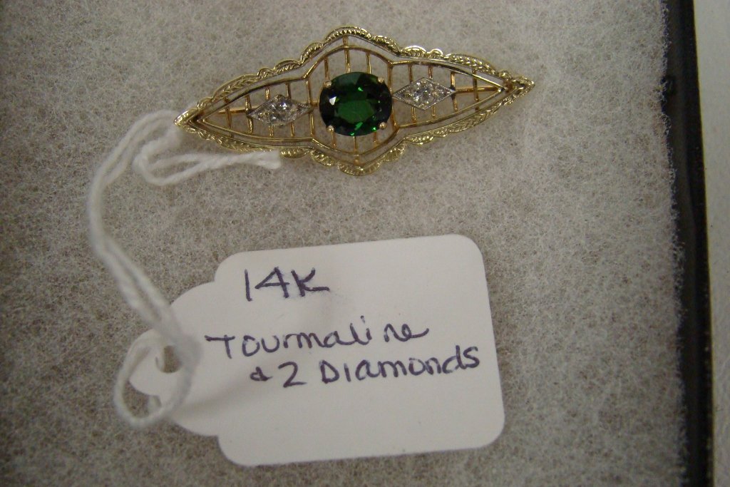 A 14 kt yellow gold brooch with tourmaline center : center stone and 2 side diamonds