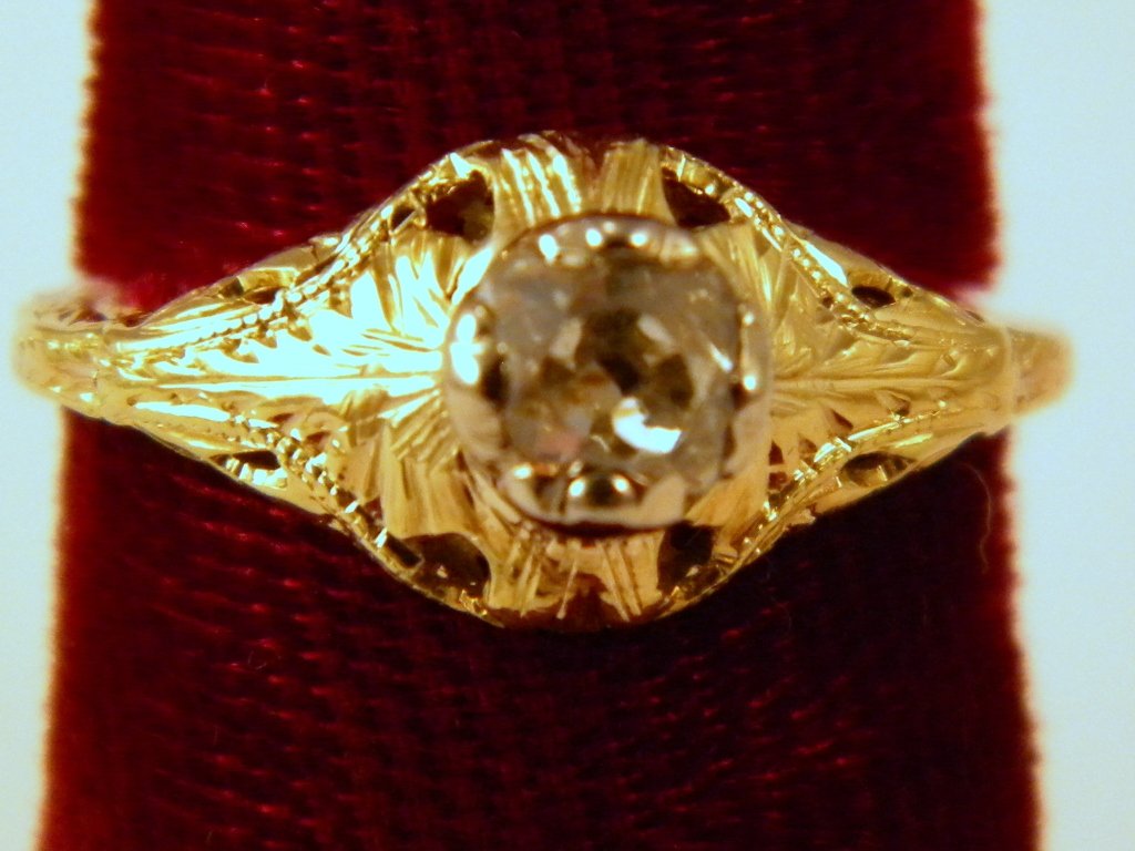An 18kt filigree yellow gold ring with center diam: diamond round European cut, .63 ct,, top-light brown in color, SI-2/SI-3; size 5, unmarked but tested, size 5 1/2
