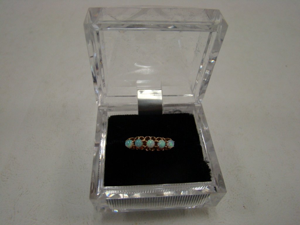 A 14kt yellow gold unmarked but tested ring with 5: with 5 opals, size 6