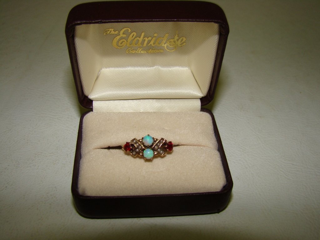 A Victorian 10kt gold ring with 10 seed pearls, 2: pearls, 2 opals and 2 garnets, size 5.25