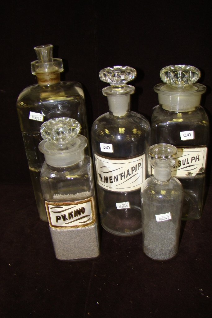 Five pharmaceutical bottles, 3 with labels