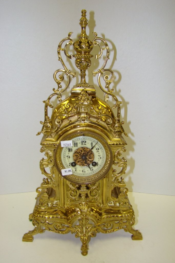 An ornate brass chiming mantle clock with reticula: reticulated case