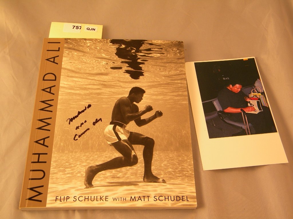 A paperback book 8" X 10" entitiled "Muhammad Ali": "Muhammad Ali" signed on the cover "Muhammad Ali aka Cassius Clay" and signed 8 more times on pictures inside the book, with picture of Ali signing