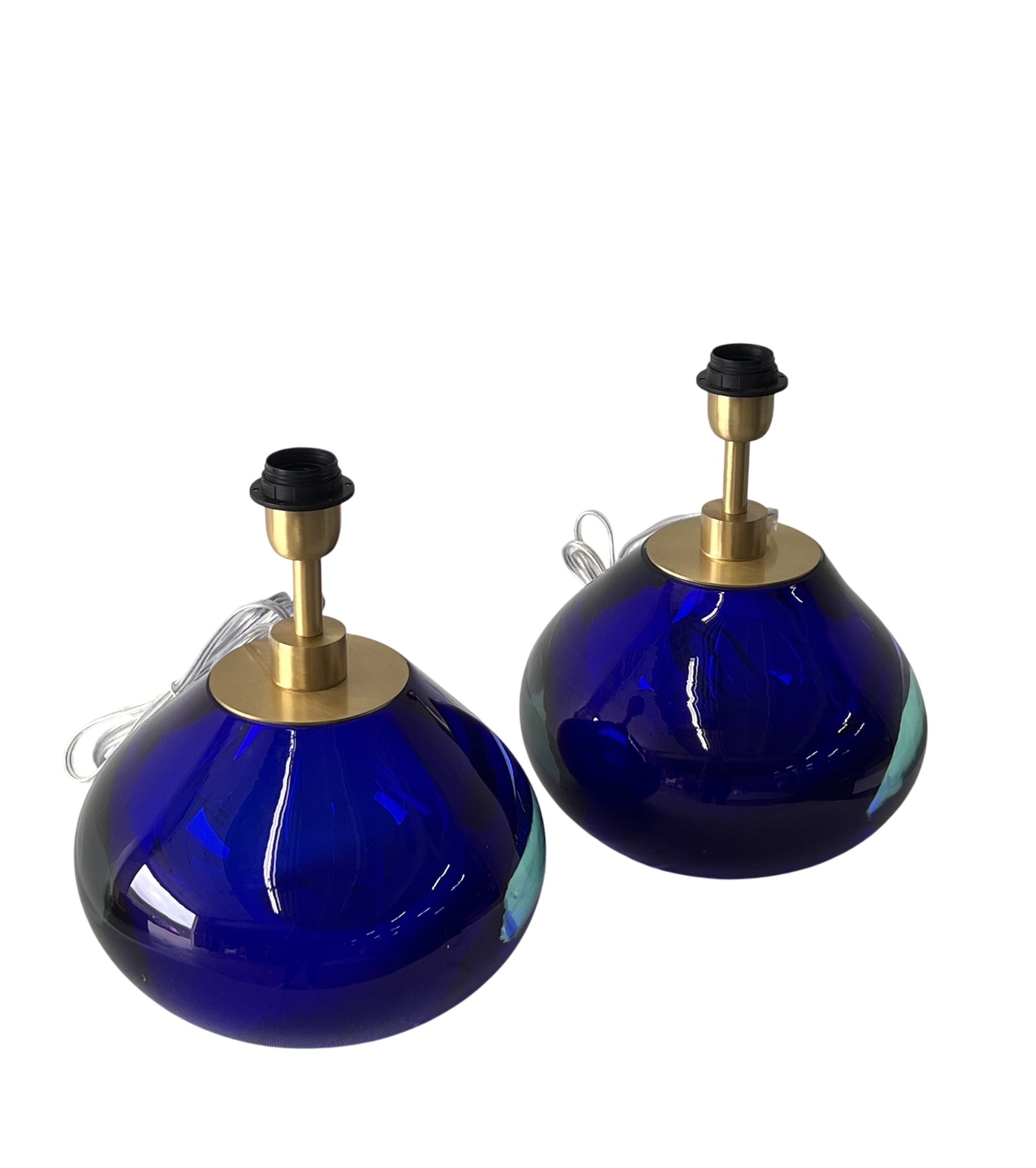 Glass Blue Table Lamps: Murano glass blue table lamps signed by Alberto Dona. Made by hand in Murano, Italy.These lamps have a sleek, dark blue color with elegant brass stems that add a touch of sophistication. Perfect for a