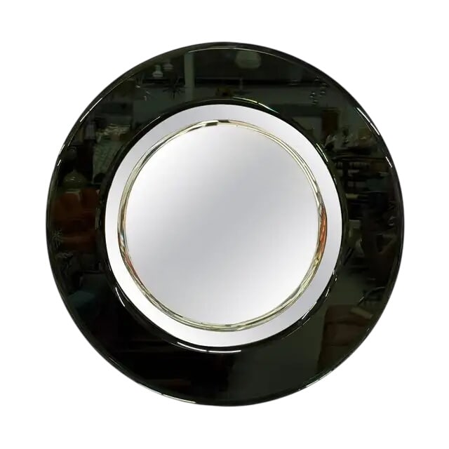 Vintage Space Age Wall Mirror: Vintage Mid-Century Modern Space Age Wall Mirror It is crafted with a distinctive dark smoked glass outer frame that surrounds a clear, beveled circular central mirror. Circa 1960s – 1970s Attribute