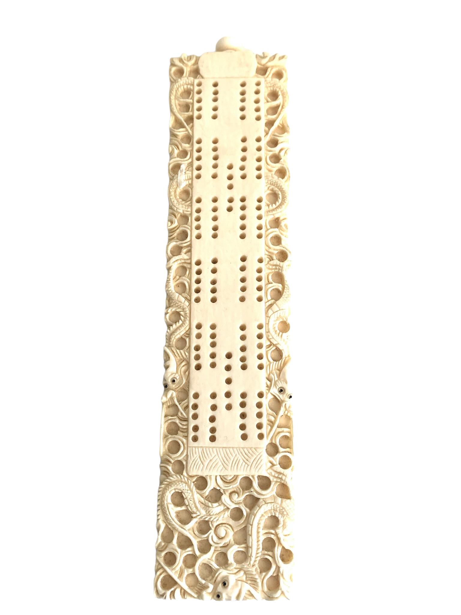 A bone carved cribbage board: 8.5''x 2''; A bone carved cribbage board;