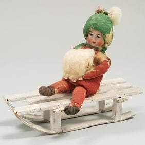Antique German Heubach bisque head & cotton child sitting on sled (color losses) 4 1/4" long
