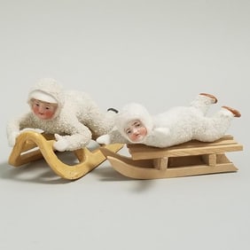2 antique bisque Snow Babies on sleds - 1 sled is wood; approx. 3 1/2"L