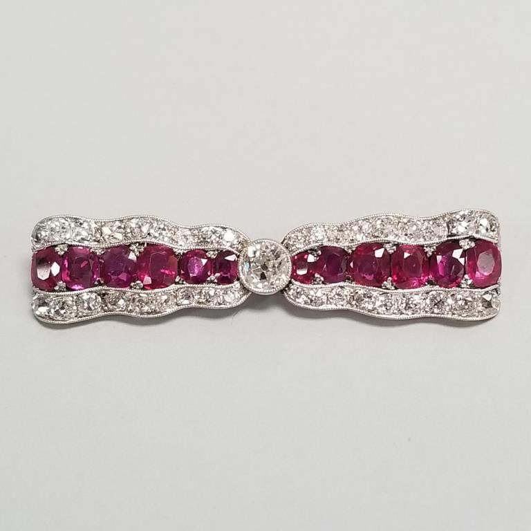 Natural ruby & diamond brooch set in platinum & 14k gold- 12 rubies approx 5.0tcw, approx 0.60ct: Natural ruby & diamond brooch set in platinum & 14k gold- 12 rubies approx 5.0tcw, approx 0.60ct center diamond K-L/ SI-2, 36 diamonds approx 1.8tcw (6 chipped) 1 1/8"L 1/2"W (unmarked tested platinum