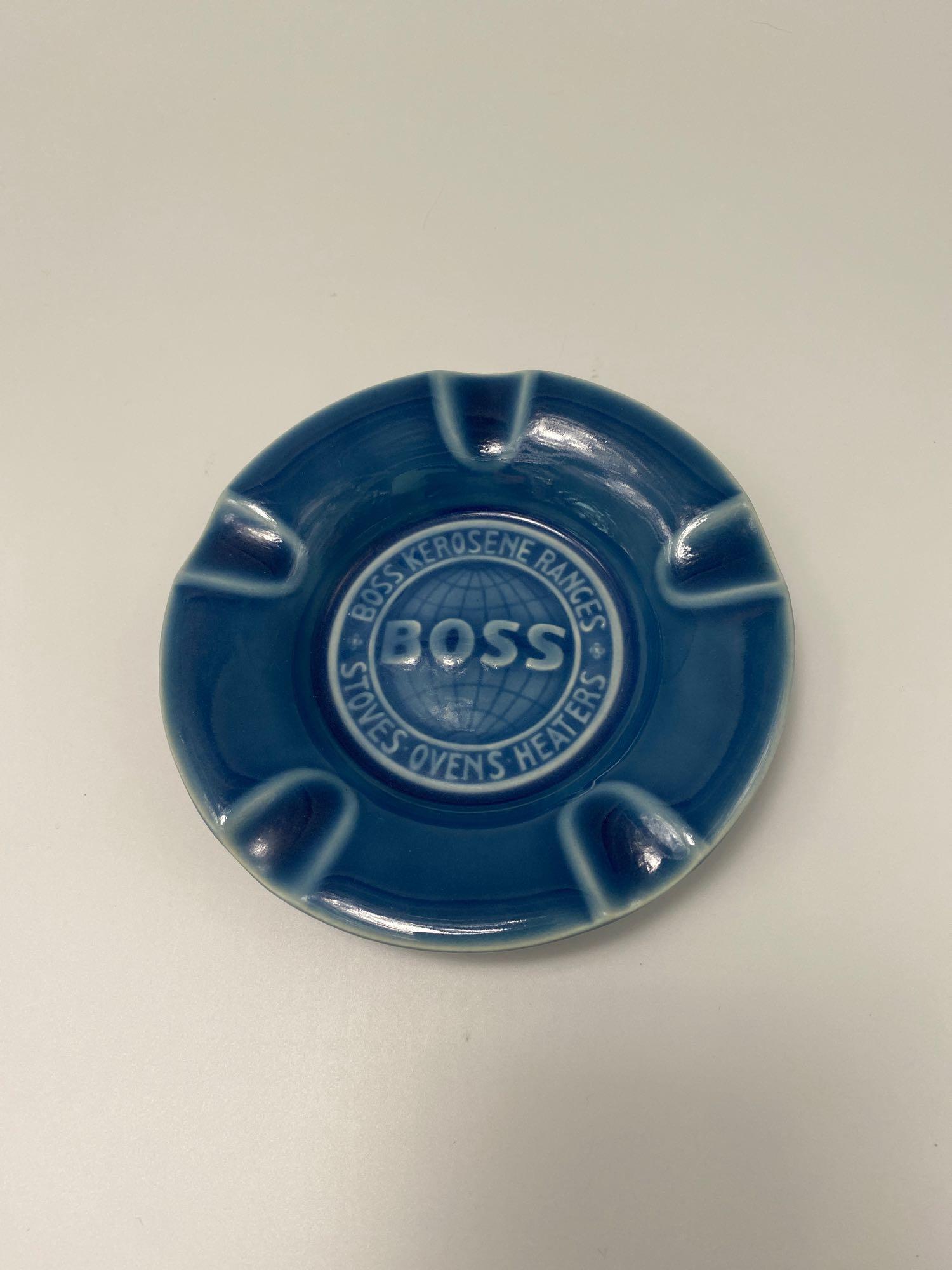 1947 Rookwood Pottery Ashtray "BOSS KEROSENE RANGES": 1947 Rookwood Pottery Ashtray in deep blue finish measuring 5.75" diameter. Embossed BOSS on the front, with Boss Kerosene Ranges, Stoves Ovens Heaters. The back has 1872-1947 The Huenefeld Co. Ci
