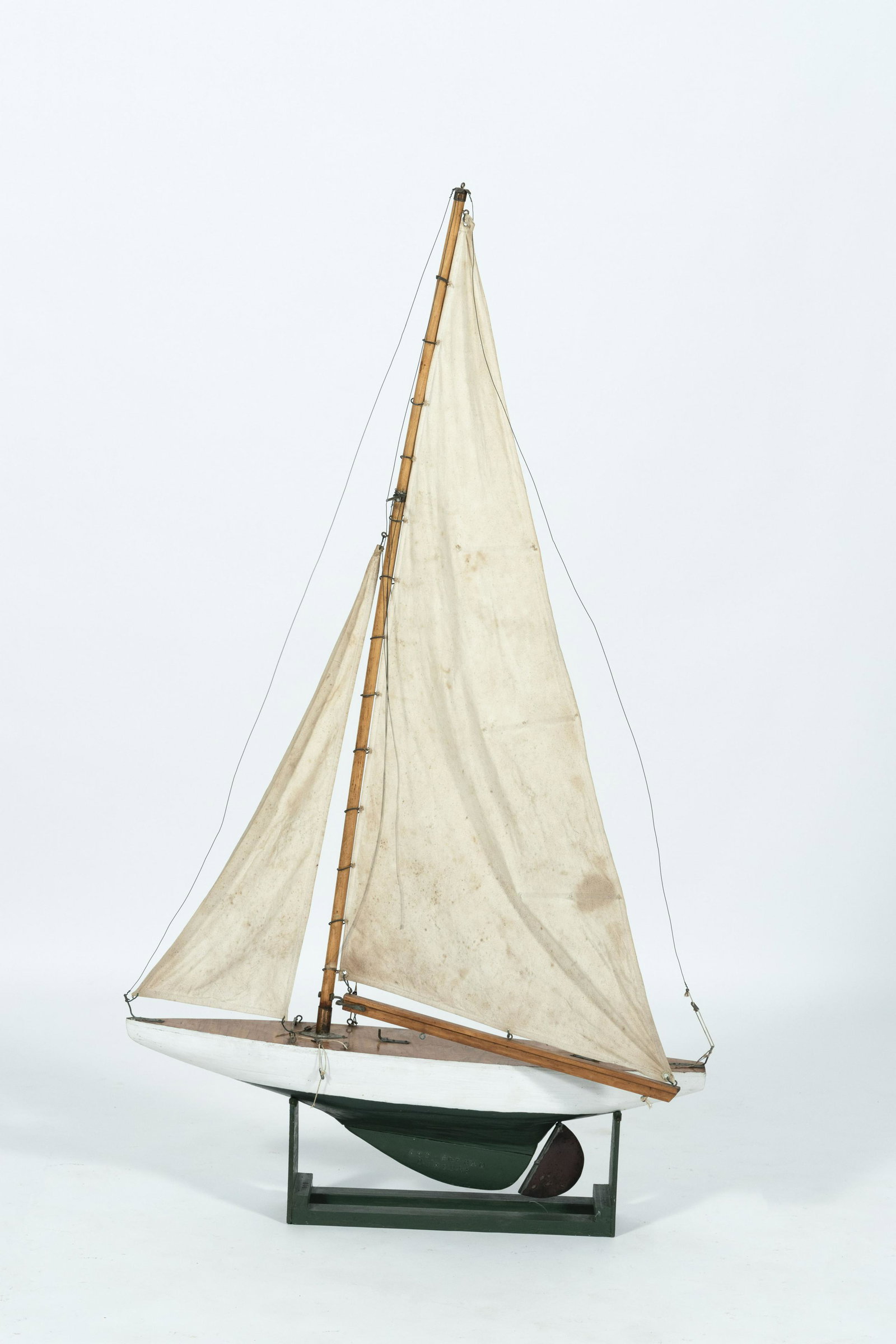 POND MODEL White and green wooden hull. Cotton sails.: POND MODEL Circa 1880 White and green wooden hull. Cotton sails. Stamped on keel "N.C. Rodham Duxbury". Displayed on a green cradle. Height 53.5". Length 30".
