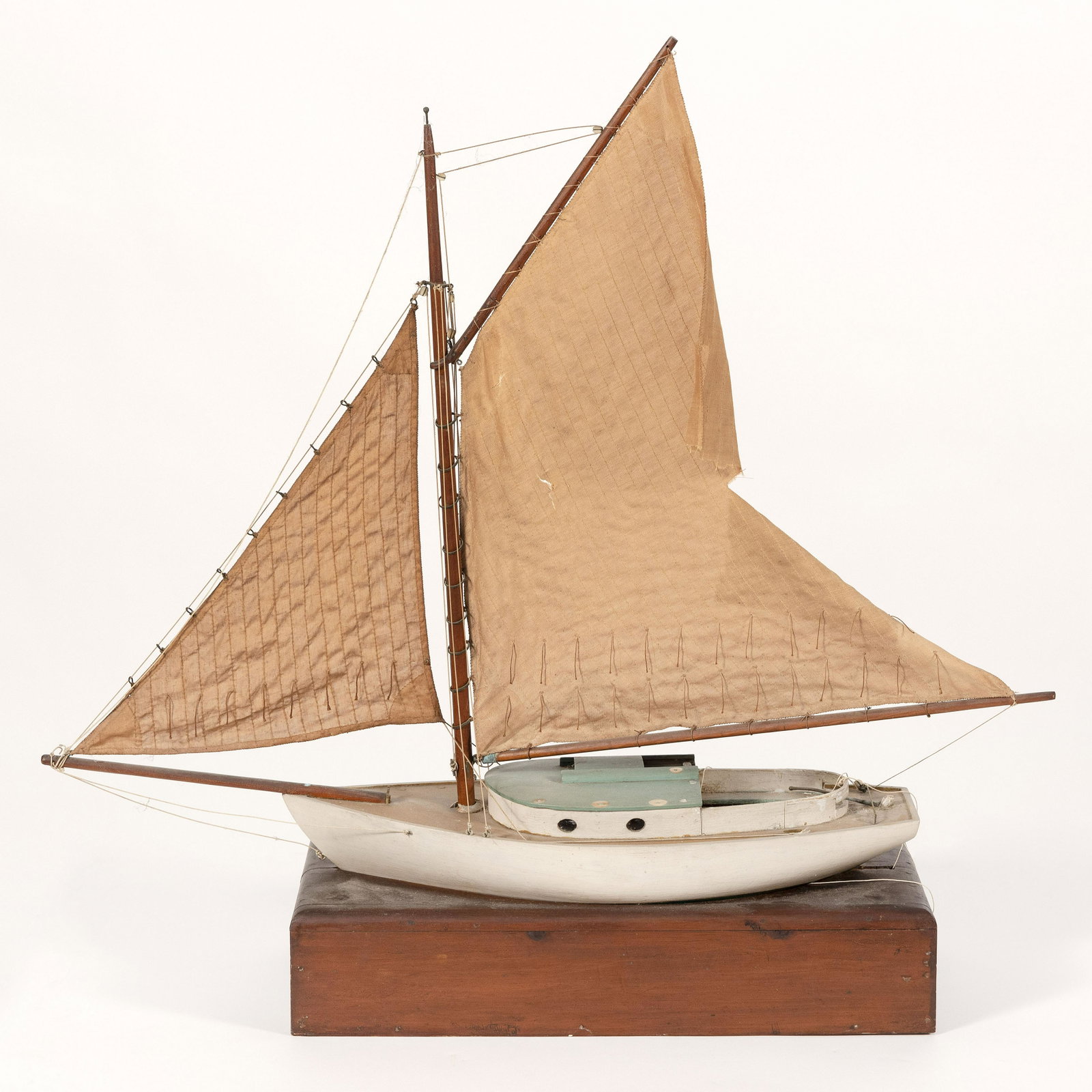 POND MODEL OF A CATBOAT White hull, with green: POND MODEL OF A CATBOAT White hull, with green topsides. Gaff-rigged with fabric sails. Displayed on a custom fitted stand. Height 31". Length 28".