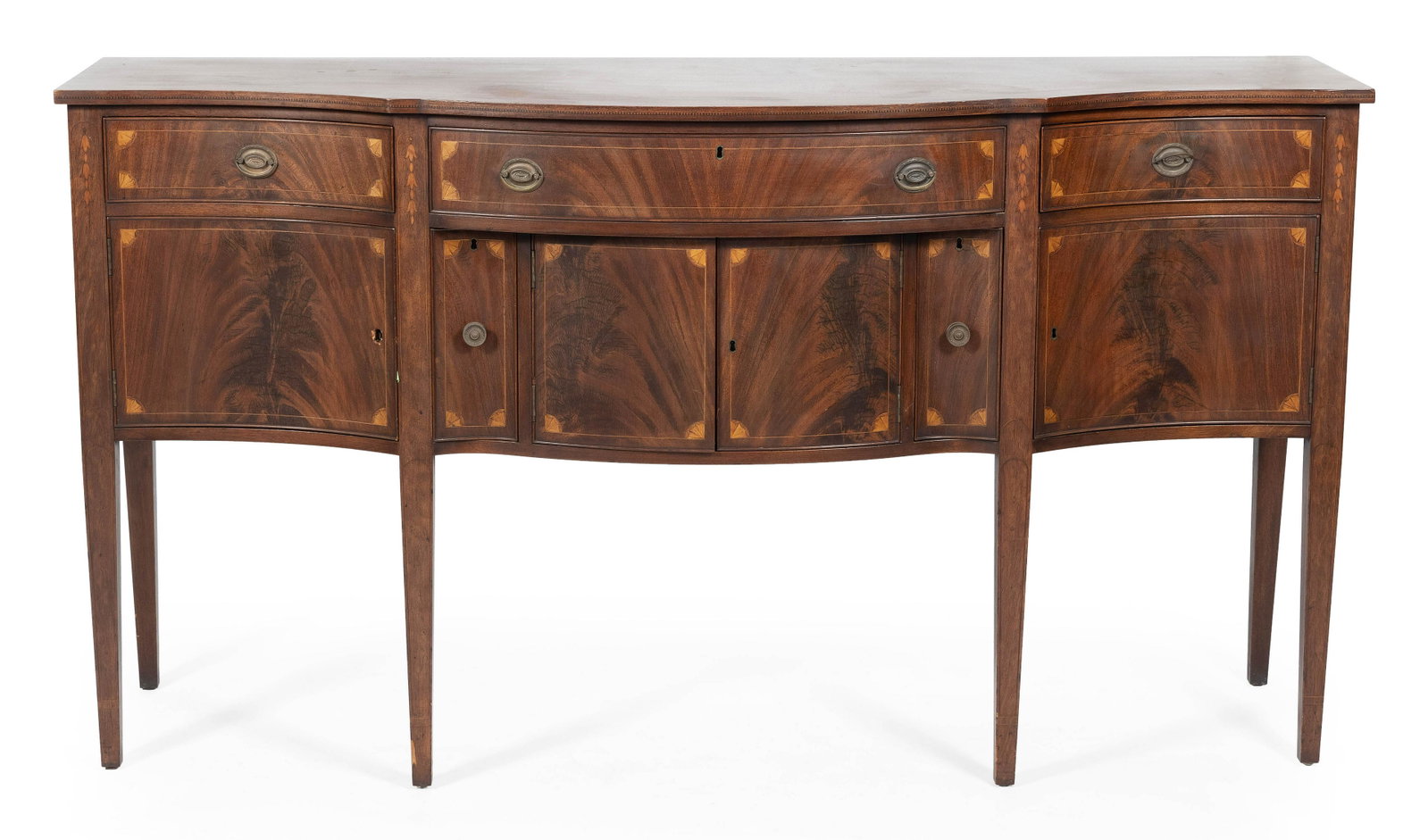 HEPPLEWHITE-STYLE SERPENTINE-FRONT SIDEBOARD In: HEPPLEWHITE-STYLE SERPENTINE-FRONT SIDEBOARD Late 19th/Early 20th Century In mahogany, with corner fan, bellflower and string inlay throughout. Height 39.5". Width 72.5". Depth 23.5".