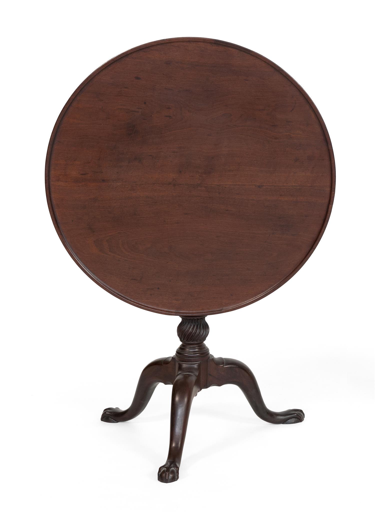 CHIPPENDALE TILT-TOP TEA TABLE In mahogany. Dish top on: CHIPPENDALE TILT-TOP TEA TABLE Rhode Island, Circa 1780 In mahogany. Dish top on a birdcage mount. Pedestal with fluted columns and fluted knop. Cabriole legs end in rat's-paw feet. Height 28". Diamet