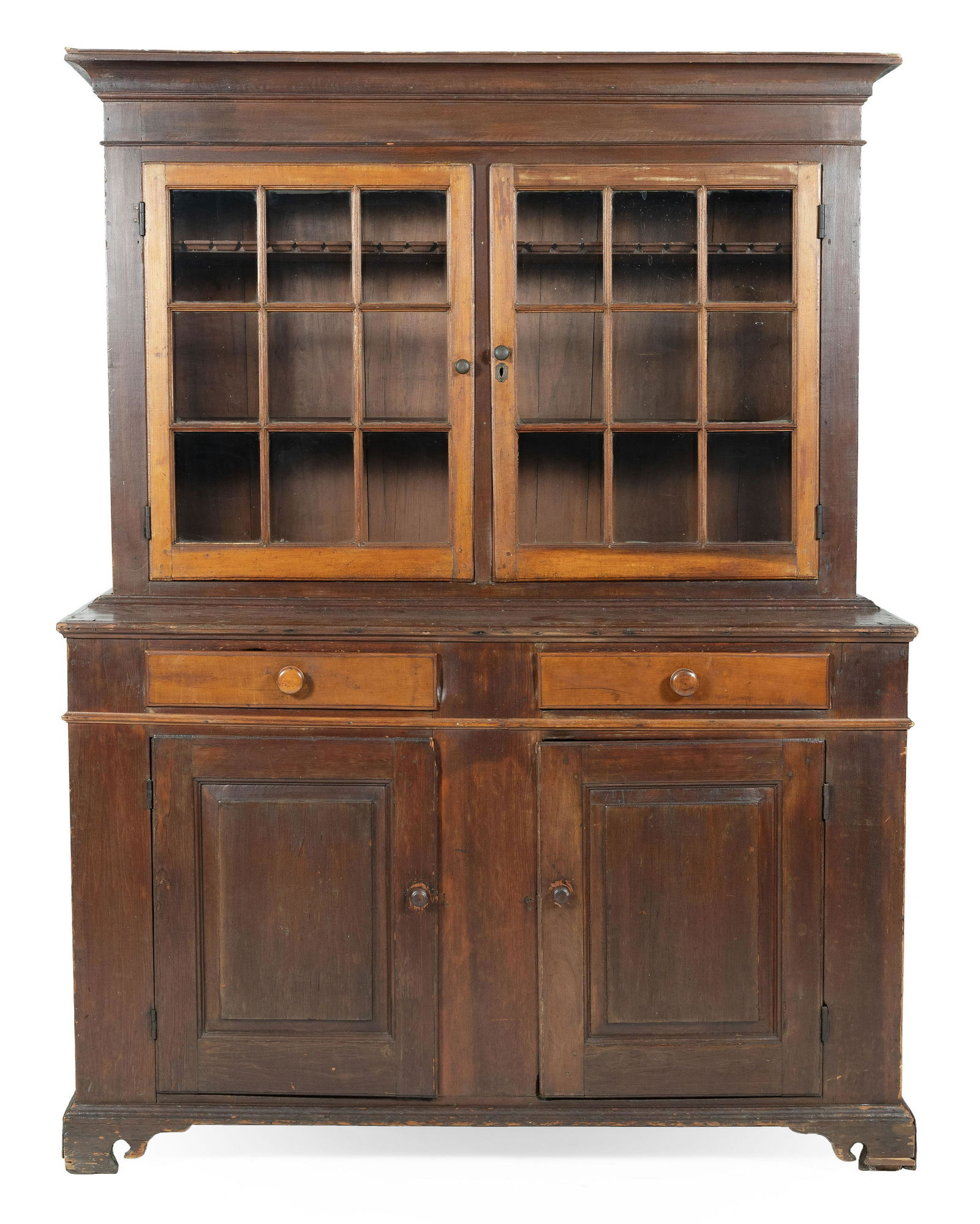 TWO-PART STEP-BACK CUPBOARD In pine, maple and other: TWO-PART STEP-BACK CUPBOARD 19th Century In pine, maple and other woods, under a brown stain. Upper section with a molded cornice over two paneled glass doors enclosing two interior shelves. Lower sec