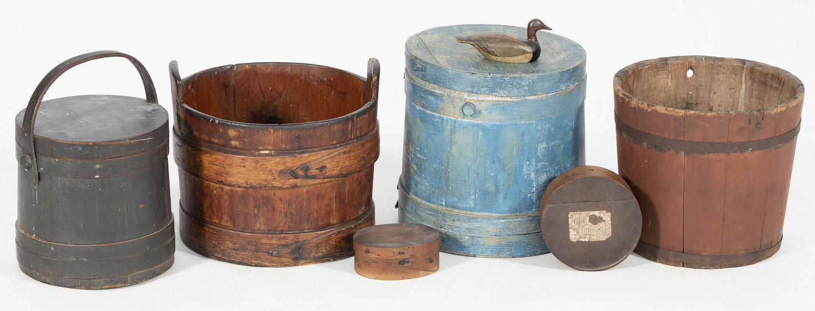 SEVEN ASSORTED WOODEN ITEMS 1-2) Two covered firkins,: SEVEN ASSORTED WOODEN ITEMS 19th Century 1-2) Two covered firkins, one painted blue and the other dark green. 3-4) Two pantry boxes, one oval and one circular. 5-6) Two wooden buckets, one painted red
