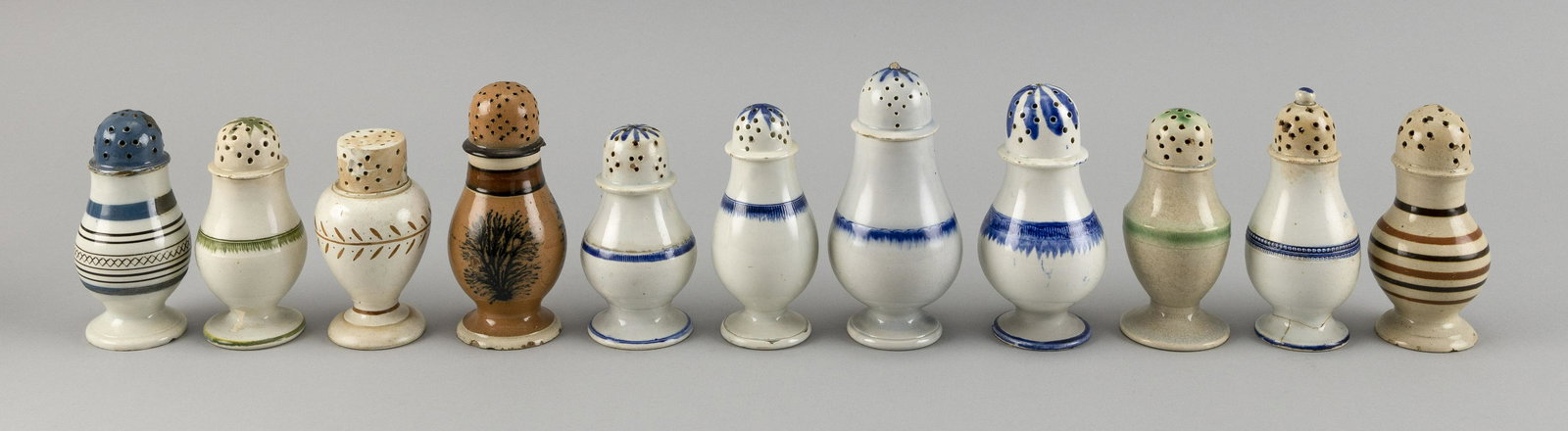 ELEVEN MOCHAWARE SOFT-PASTE PORCELAIN PEPPER POTS: ELEVEN MOCHAWARE SOFT-PASTE PORCELAIN PEPPER POTS 19th Century Heights from 3.75" to 4.75".