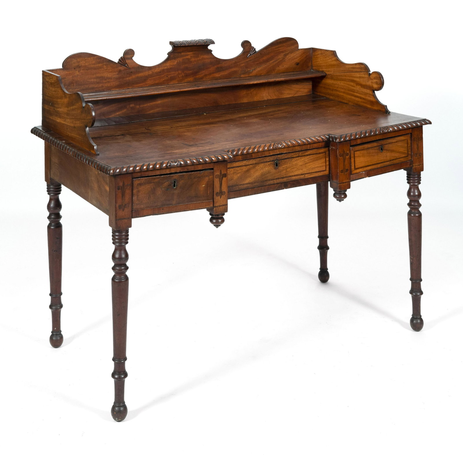 SHERATON DESK In mahogany and pine. Shaped backsplash.: SHERATON DESK Circa 1820 In mahogany and pine. Shaped backsplash. Three drawers with string and geometric inlay. Tapered legs end in ball feet. Height 41". Width 50.25". Depth 26.75".