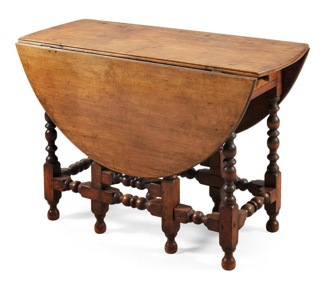 GATELEG TABLE In maple and other hardwoods. Apron with: GATELEG TABLE New England, 18th Century In maple and other hardwoods. Apron with a single drawer at one end. Nicely turned base. Height 28.5". Length 17.5" plus two 16.75" drop leaves. Width 41.5". Re
