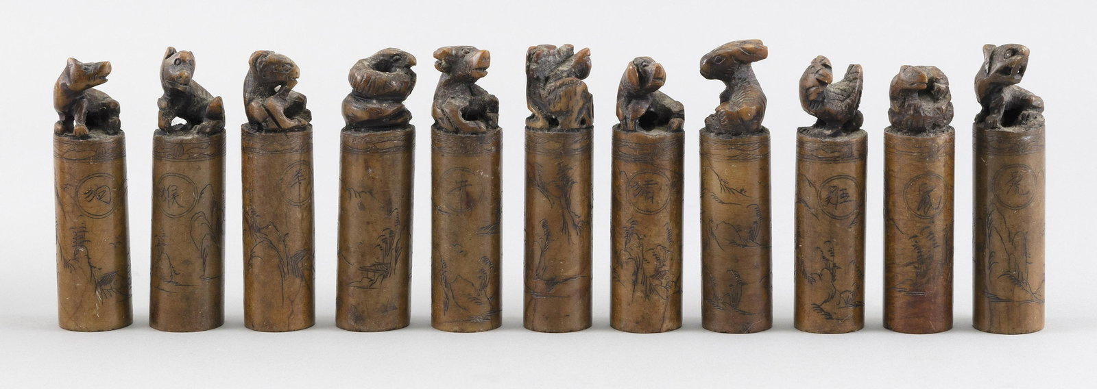 SET OF ELEVEN SOAPSTONE SEALS Late 19th Century Heights: SET OF ELEVEN SOAPSTONE SEALS Late 19th Century Most likely representing the animals of the zodiac, one missing. Each cylindrical, mounted with a carved animal and incised with a mountainous landscape