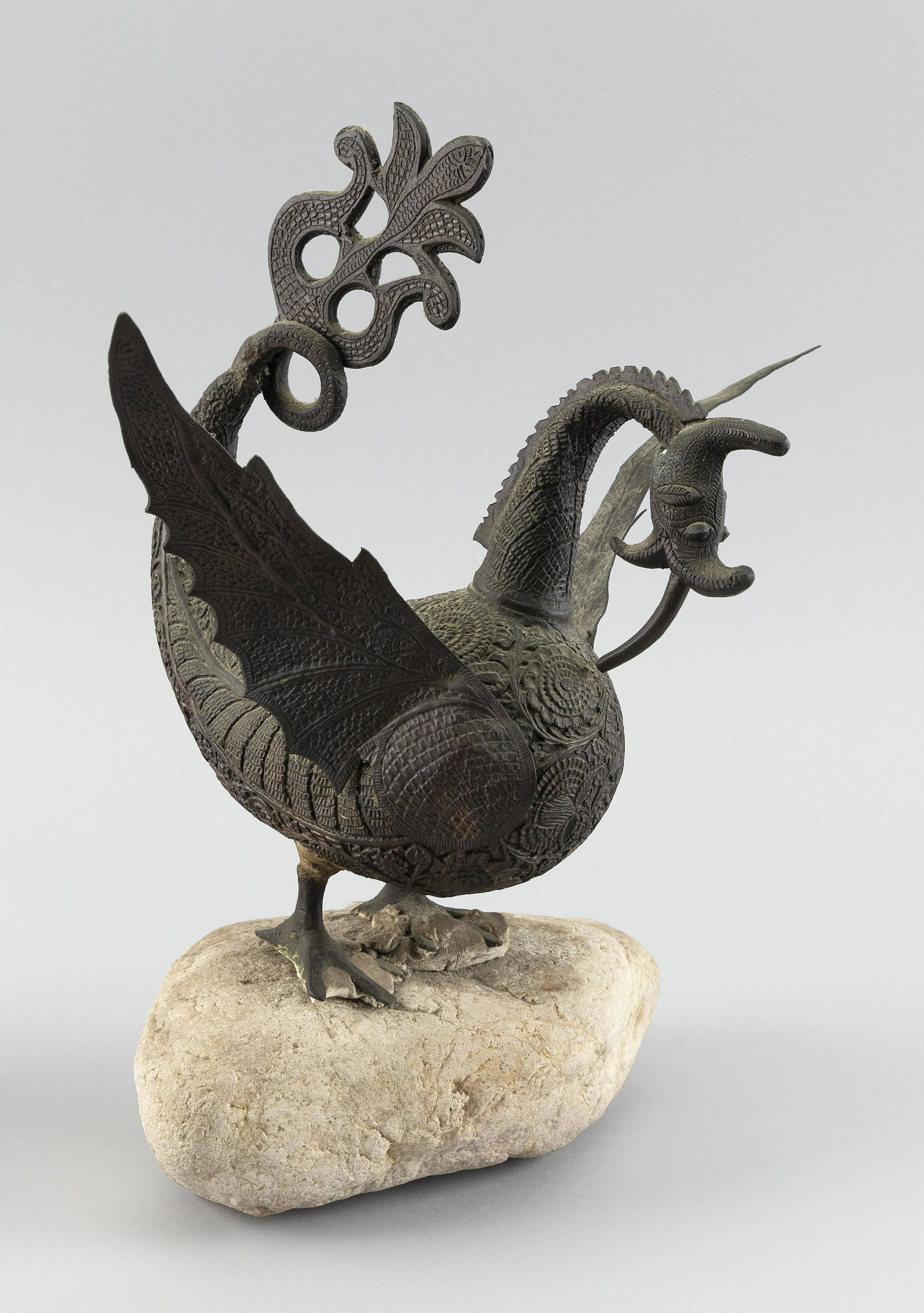 BURMESE METAL HINTHA BIRD FIGURE Early 20th Century: BURMESE METAL HINTHA BIRD FIGURE Early 20th Century Body with chased floral and scroll decoration. Applied wings. Mounted on a rock. Figure height 10". Total height 13".