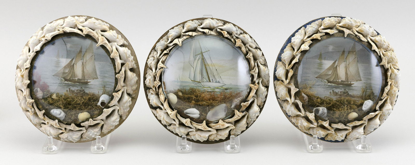 THREE ENGLISH SHELLWORK PICTURE FRAMES Late 19th/Early: THREE ENGLISH SHELLWORK PICTURE FRAMESLate 19th/Early 20th CenturyEach contain a watercolor maritime scene.Overall diameters 6".