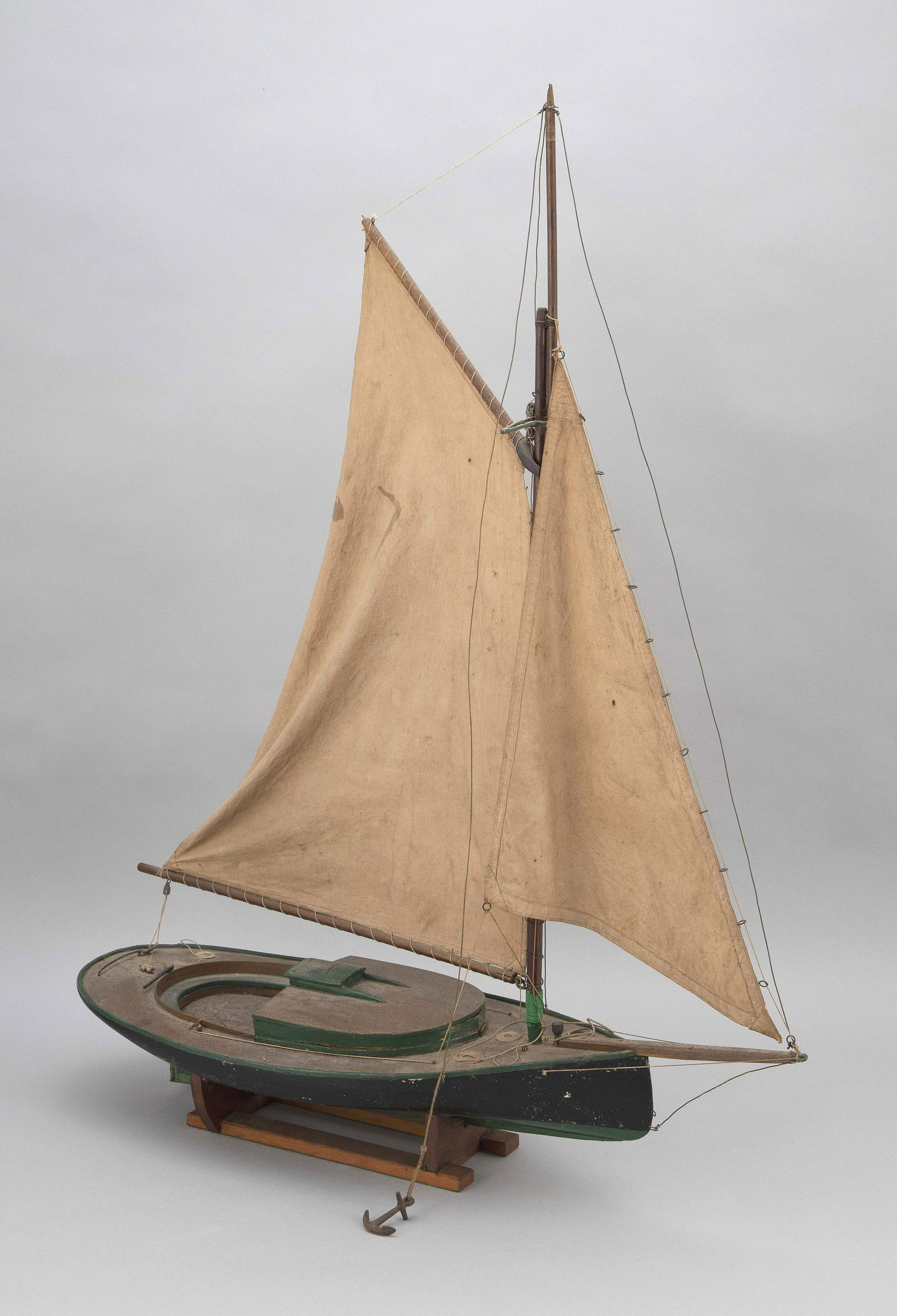 CATBOAT POND MODEL America, Early 20th Century Height: CATBOAT POND MODELAmerica, Early 20th CenturyBlack and green hull. Gaff-rigged sails.Height 37". Length 29".