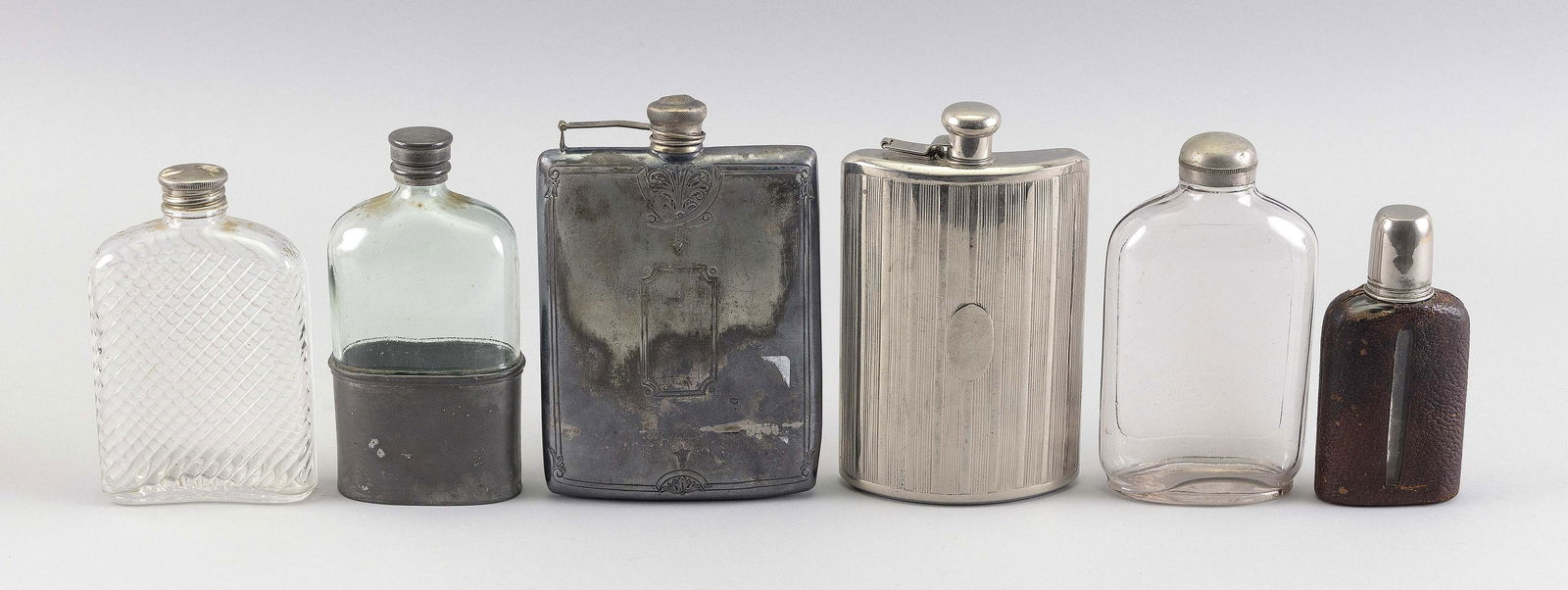 SIX ASSORTED GLASS AND SILVER PLATED FLASKS Late: SIX ASSORTED GLASS AND SILVER PLATED FLASKSLate 19th/Early 20th CenturyHeights from 4.5" to 6".