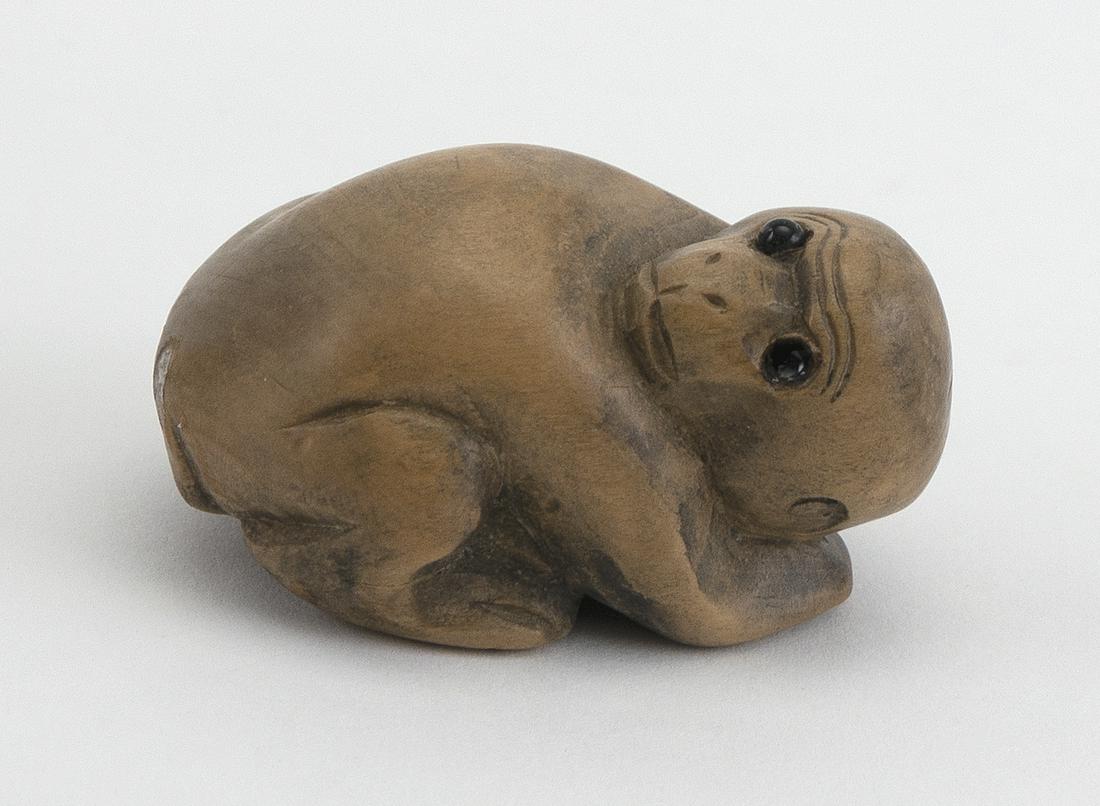 WOOD NETSUKE 20th Century In the form of a sleeping: WOOD NETSUKE 20th Century In the form of a sleeping monkey. Inlaid eyes. Height 1". Length 1.75".