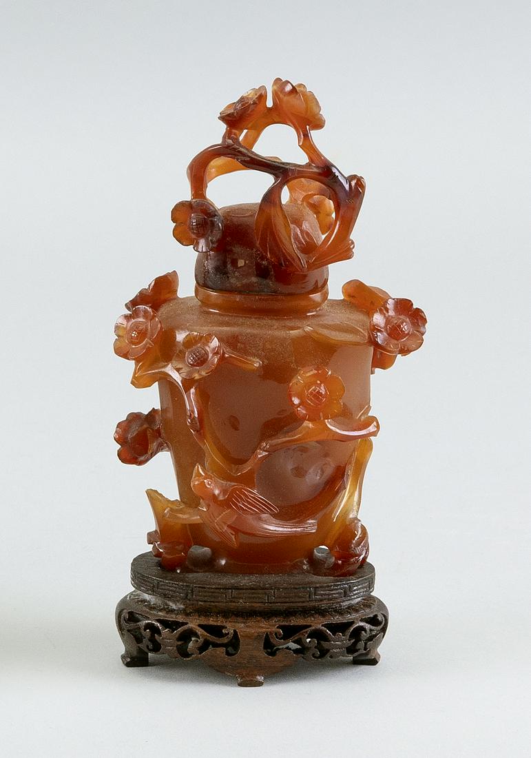 CARNELIAN AGATE COVERED VASE In temple jar form, with: CARNELIAN AGATE COVERED VASE In temple jar form, with relief-carved prunus and bird decoration. Height 4.5".