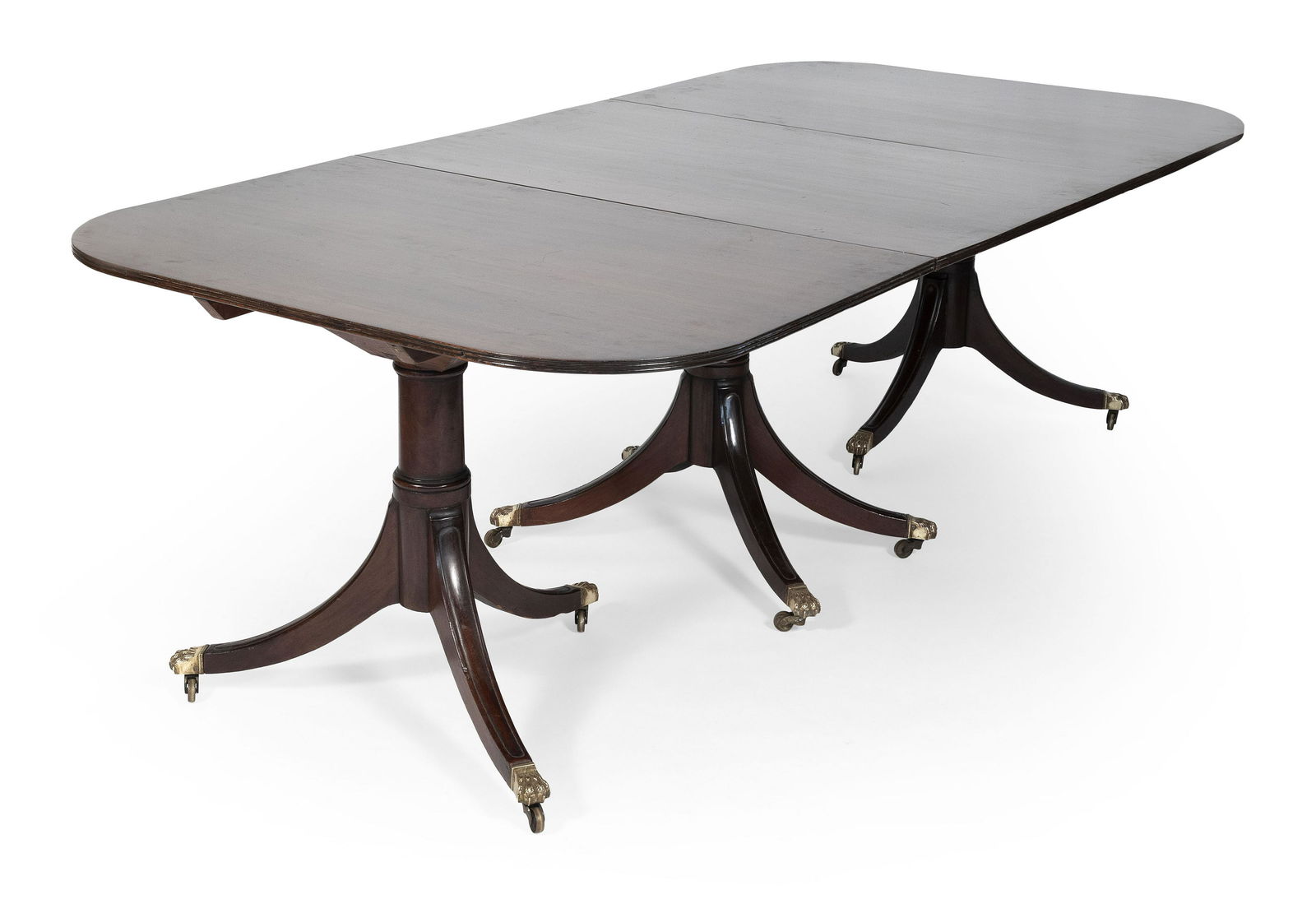 DUNCAN PHYFE-STYLE TRIPLE-PEDESTAL DINING TABLE Early: DUNCAN PHYFE-STYLE TRIPLE-PEDESTAL DINING TABLE Early 20th Century In mahogany, with brass lion's-paw feet fitted with casters. Includes two 19" leaves. Height 28.5”. Length 94.5”. Width 48”.