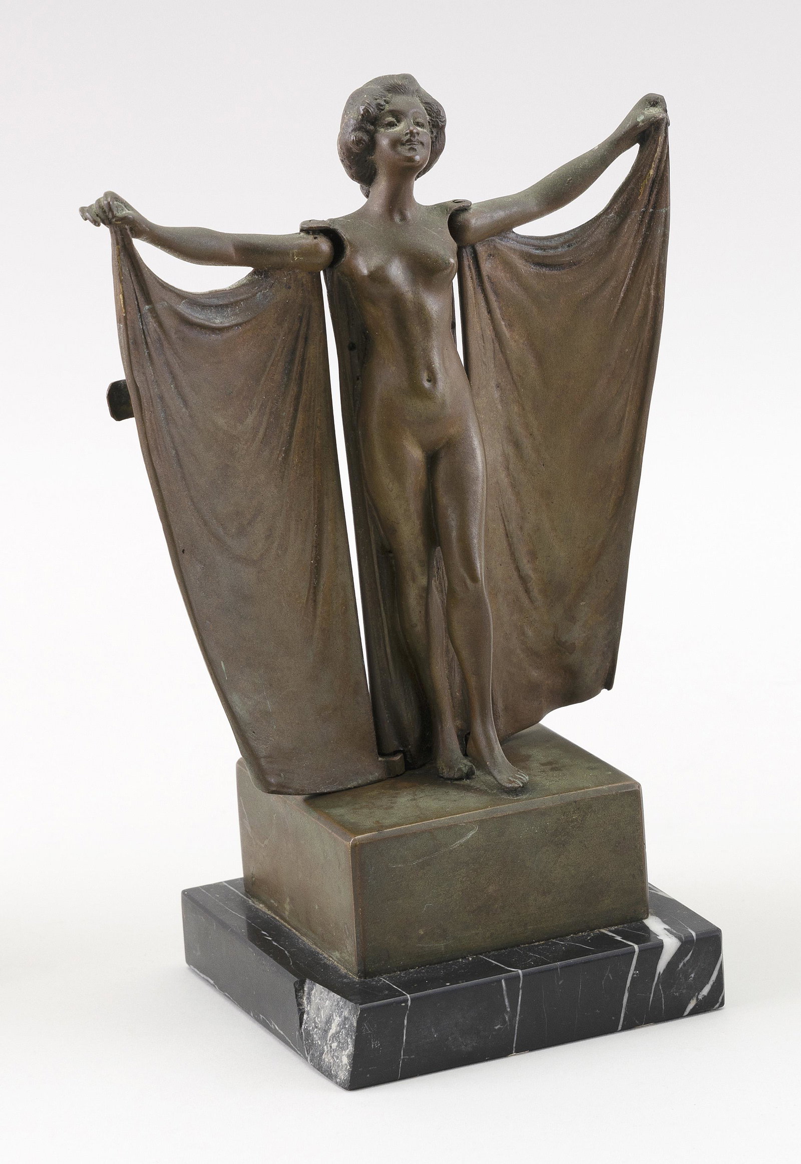 CARL KAUBA Austria/United States 1865-1922 “Revealing: CARL KAUBA Austria/United States 1865-1922 “Revealing Beauty”. Spring mechanism opens woman’s cape to reveal a nude body. Dark brown patina. Unsigned. Bronze, height 9”. Black marble base 4”