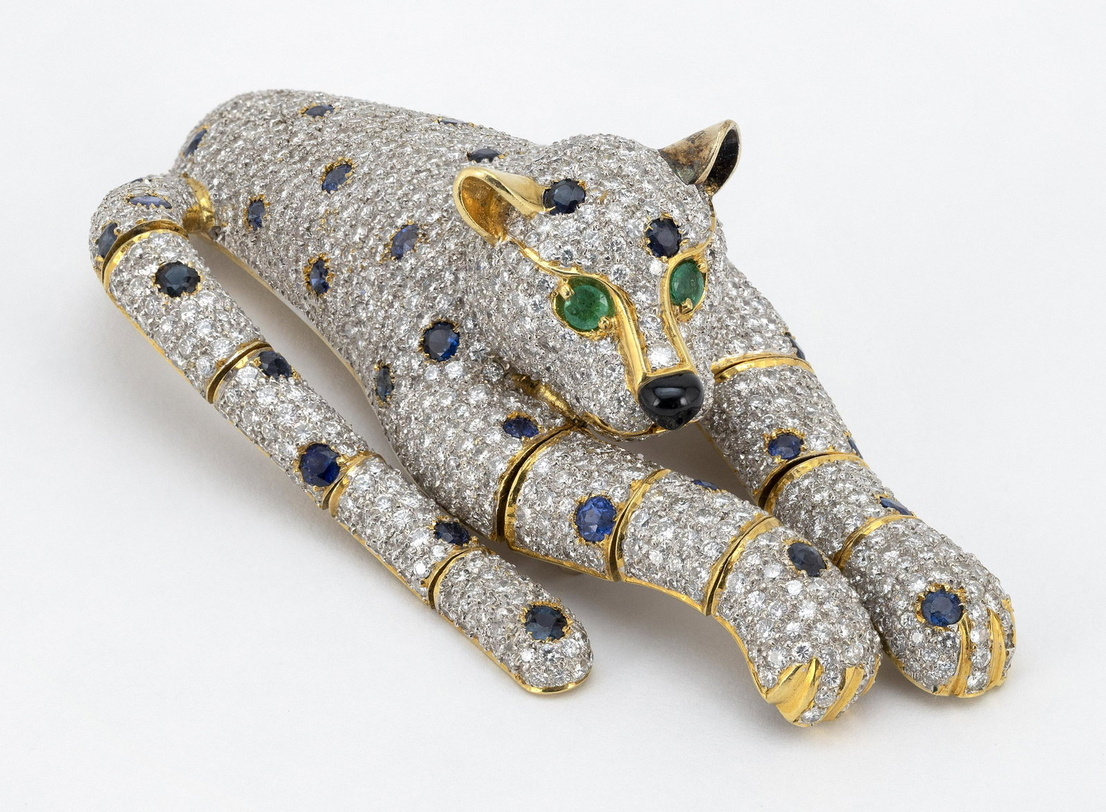 18KT GOLD, DIAMOND, SAPPHIRE AND EMERALD PANTHER-FORM: 18KT GOLD, DIAMOND, SAPPHIRE AND EMERALD PANTHER-FORM BROOCH Accented by round diamonds, total weight approx. 10.00 cts. Articulated legs and tail. Length 3”. Approx. 40.53 total dwt.