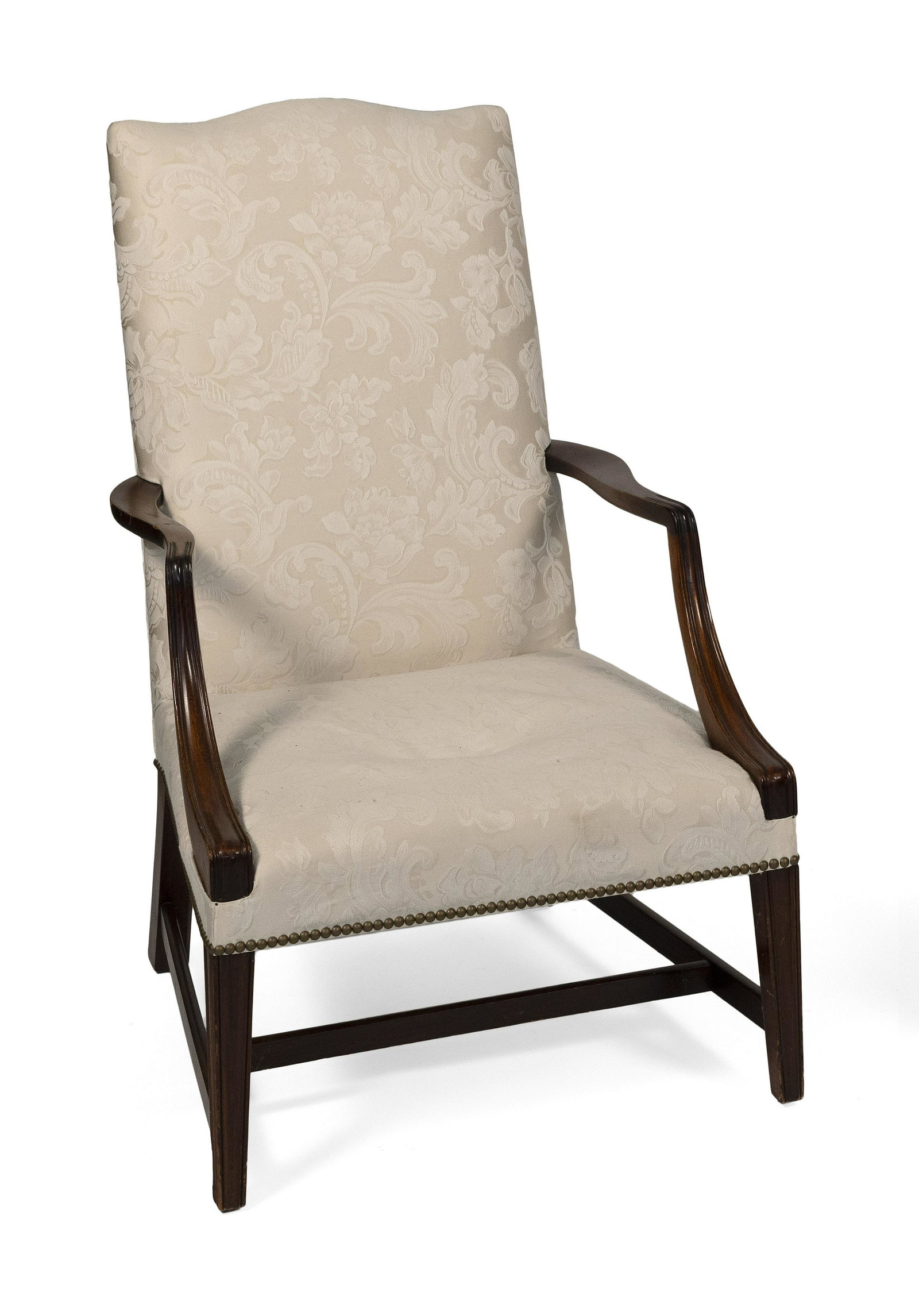 FEDERAL-STYLE LOLLING CHAIR Circa 1900 Back height: FEDERAL-STYLE LOLLING CHAIR Circa 1900 In mahogany. Legs, the front legs molded, joined by an H-stretcher. White floral print upholstery. Back height 42.25”. Seat height 16”.