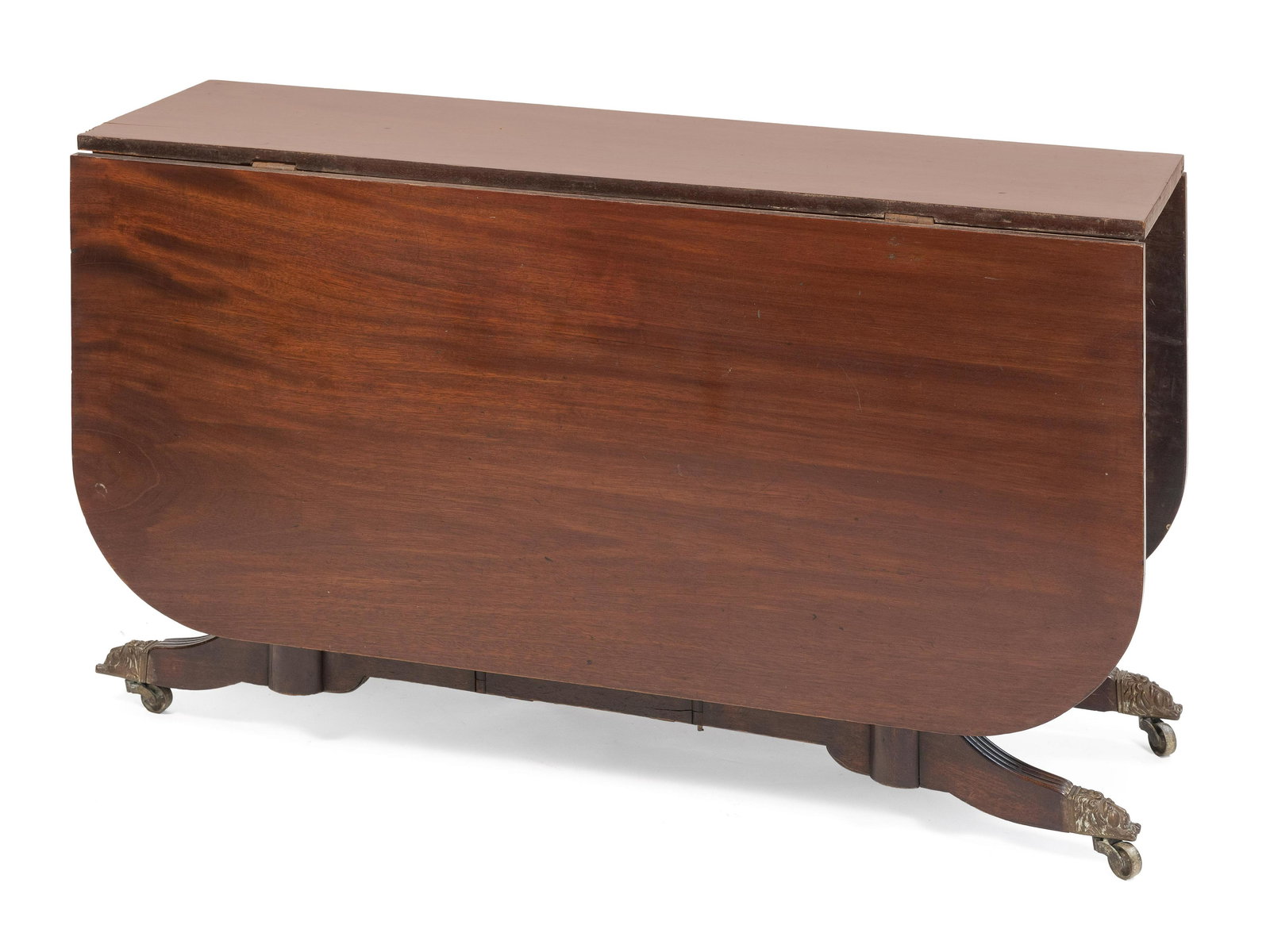 CUMBERLAND FEDERAL DROP-LEAF DINING TABLE 19th Century: CUMBERLAND FEDERAL DROP-LEAF DINING TABLE19th CenturyDuncan Phyfe style. In mahogany. Spiral-turned legs end in brass-capped lion's-head feet fitted with casters.Height 27.5”. Length 14.25” plus t