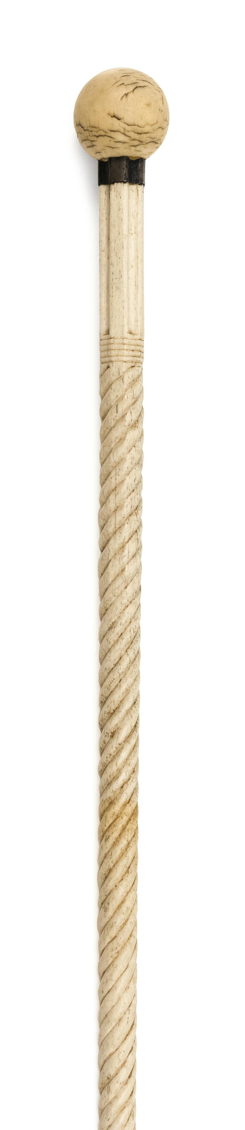 ELEPHANT IVORY AND WHALEBONE CANE: ELEPHANT IVORY AND WHALEBONE CANE Mid-19th Century Large ivory cue ball handle. Metal collar. Whalebone shaft with sections of deep fluting and ring and spiral carvings tapering to a simple cylinder. 
