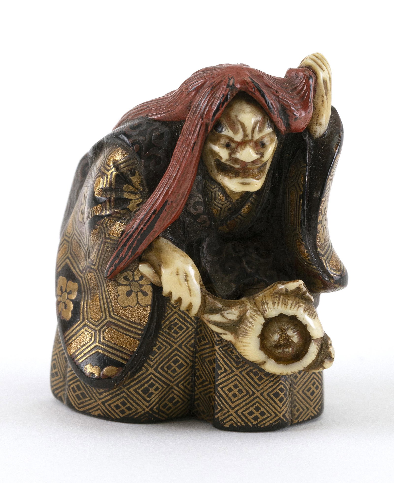 JAPANESE LACQUERED WOOD NETSUKE BY KOGYOKU Early 19th: JAPANESE LACQUERED WOOD NETSUKE BY KOGYOKU Early 19th Century An actor dressed as a witch, with red lacquer hair, a gold lacquered costume, and inlaid ivory mask, hands and flower blossom. Signed. Hei