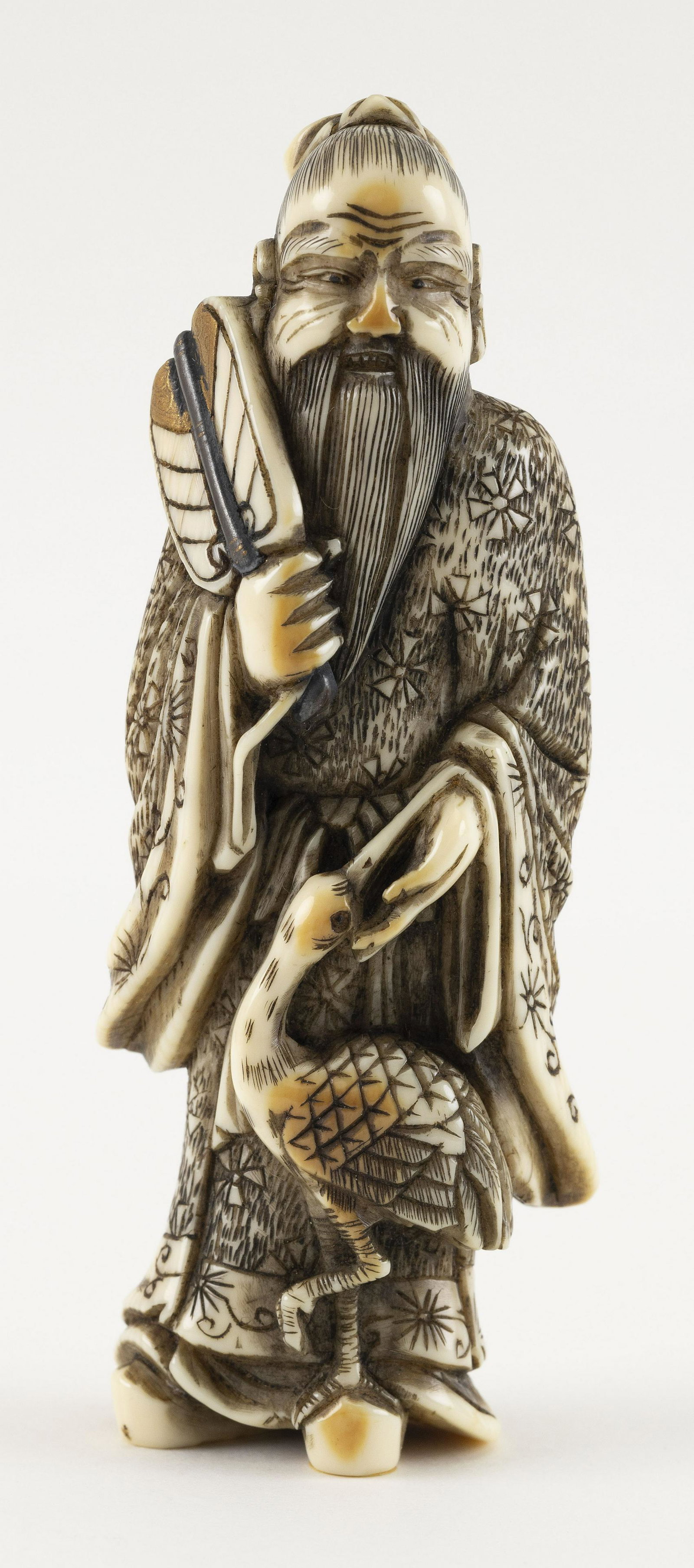 JAPANESE NETSUKE Circa 1800 Height 3.75".: JAPANESE NETSUKE Circa 1800 A sennin accompanied by a crane and holding a lacquer-decorated fan. Height 3.75". Provenance: The Collection of Gloria and Joe Kurilecz.