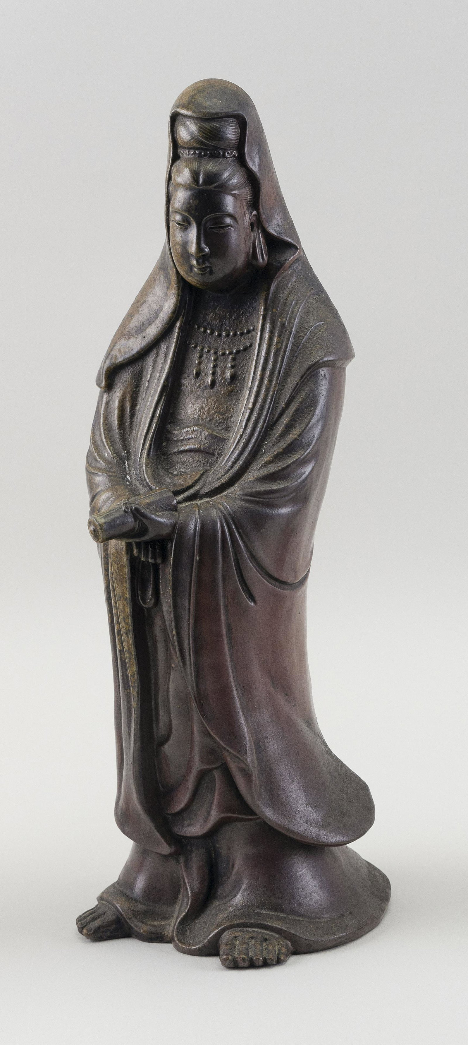 JAPANESE BIZEN POTTERY FIGURE OF KWAN YIN Late Meiji: JAPANESE BIZEN POTTERY FIGURE OF KWAN YINLate Meiji PeriodThe porcelain simulating bronze. Kwan Yin stands in her robes and holds a scroll. Gourd-form stamp inside base.Height 14.5".