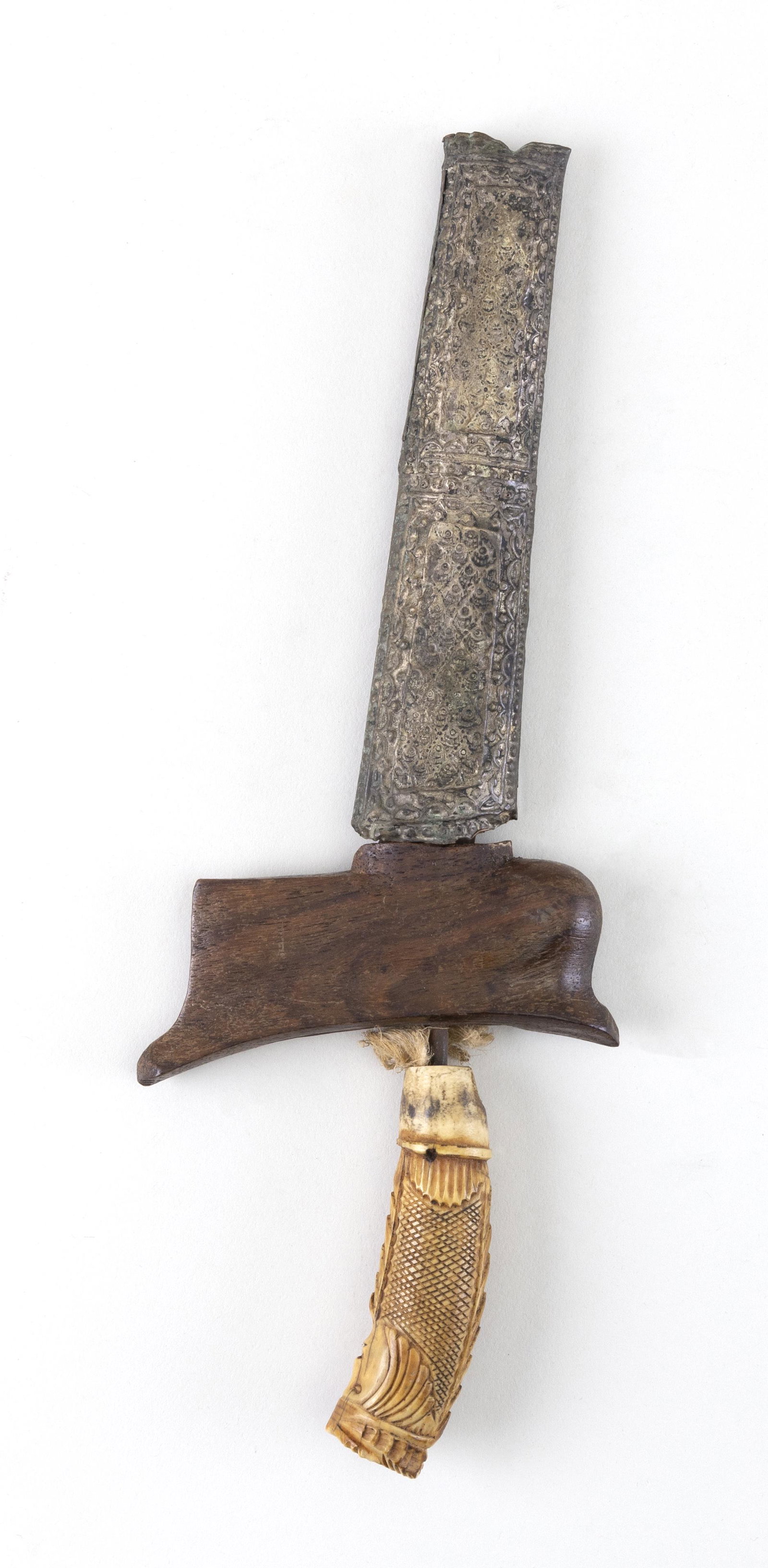 INDONESIAN KRIS WITH SCABBARD Late 19th/Early 20th: INDONESIAN KRIS WITH SCABBARD Late 19th/Early 20th Century Kris with bone figural handle and wooden sword guard. Chased silver metal scabbard. Blade length 6.5”. Total length 10”.
